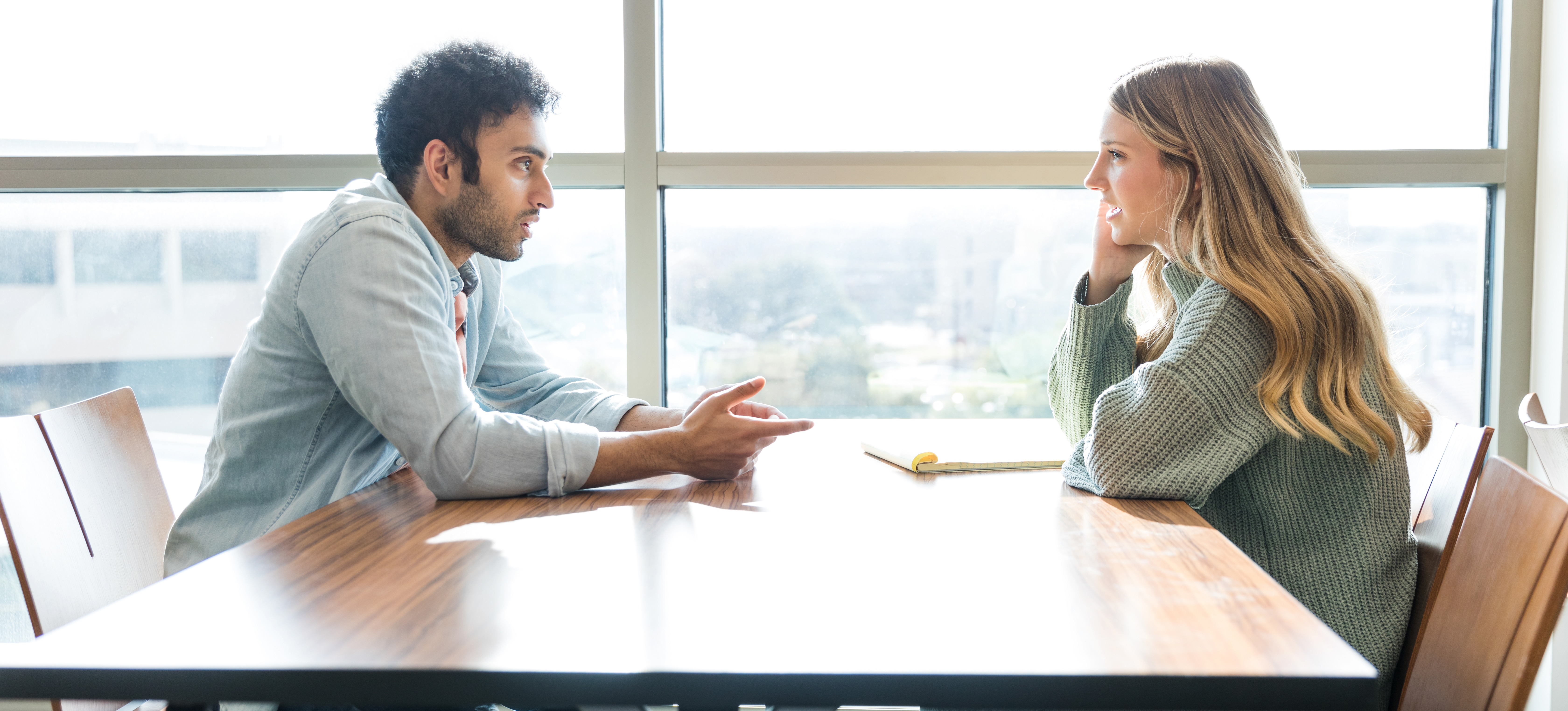 [Featured Image] A student talks with a college counselor about how many credits are needed for an associate degree.   