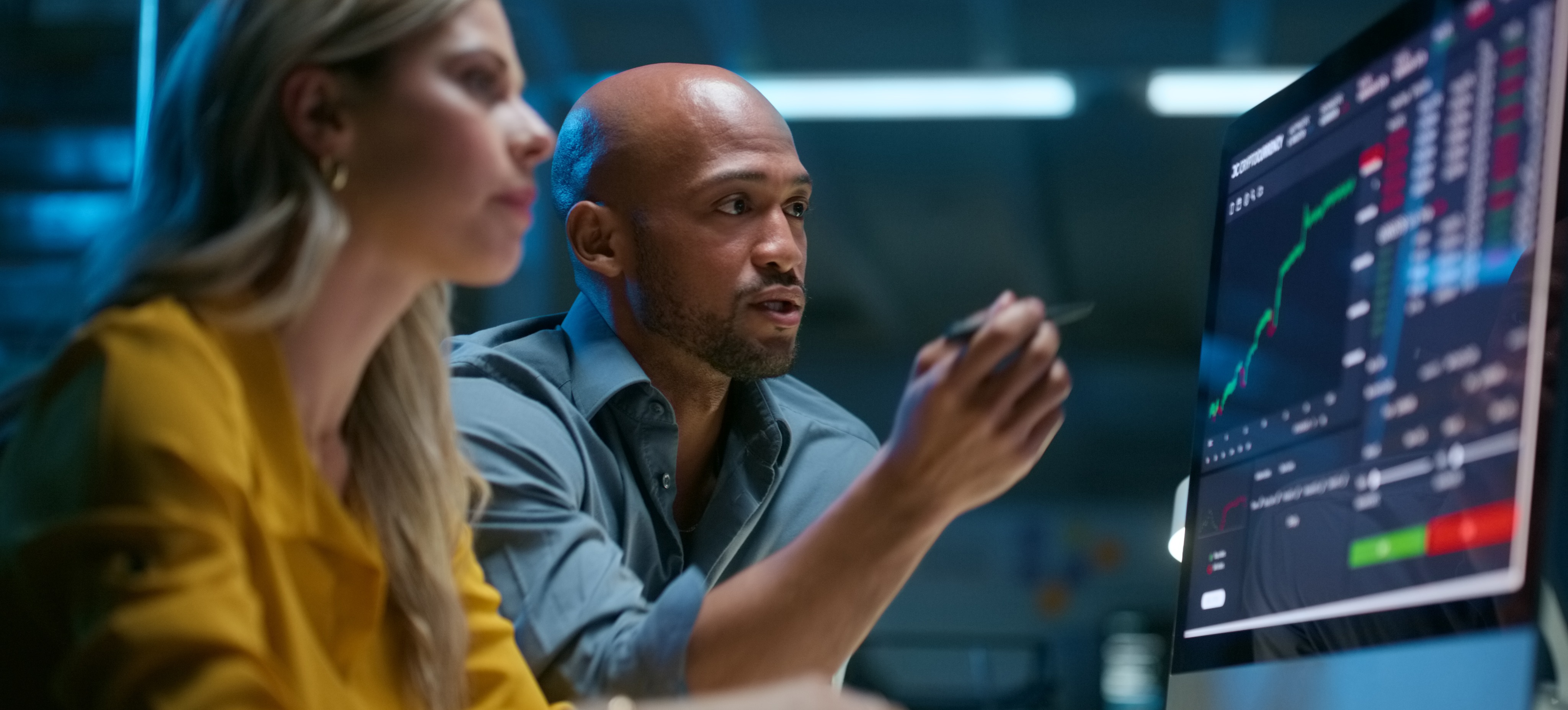 [Featured Image] Two business professionals are reading graphs on a computer available through a big data visualization tool.