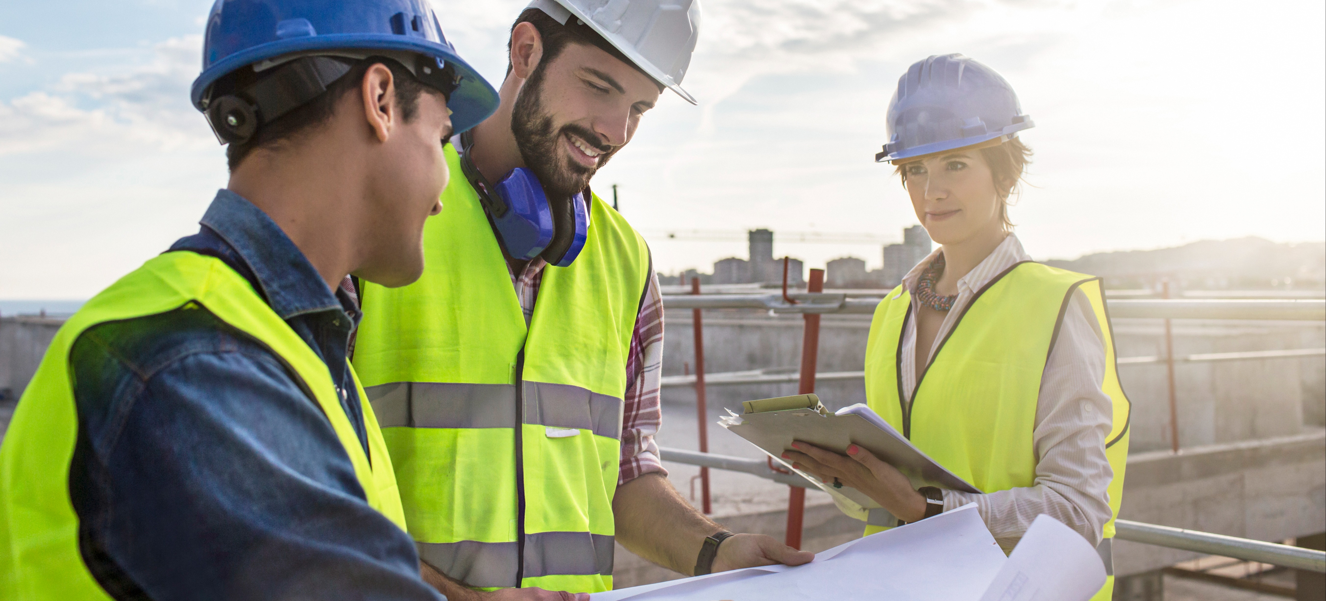 [Featured image] A civil engineer consults with a construction manager at a job site.