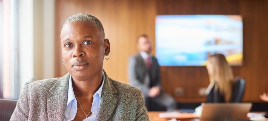 [Featured image] An HR specialist is in a conference room with their coworkers. 