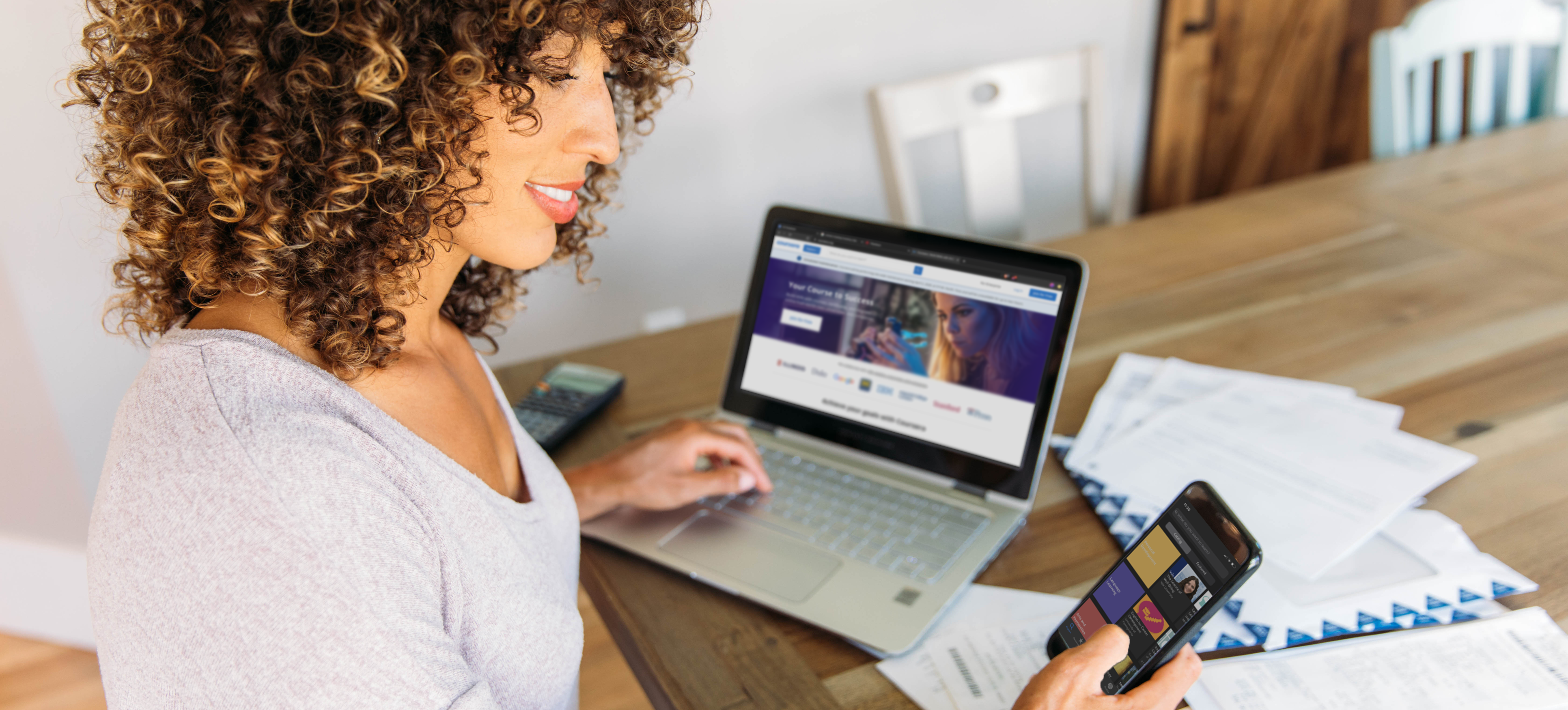 [Festured image] A woman sits at her table researching the top negative keywords for her next product launch on her laptop and phone.