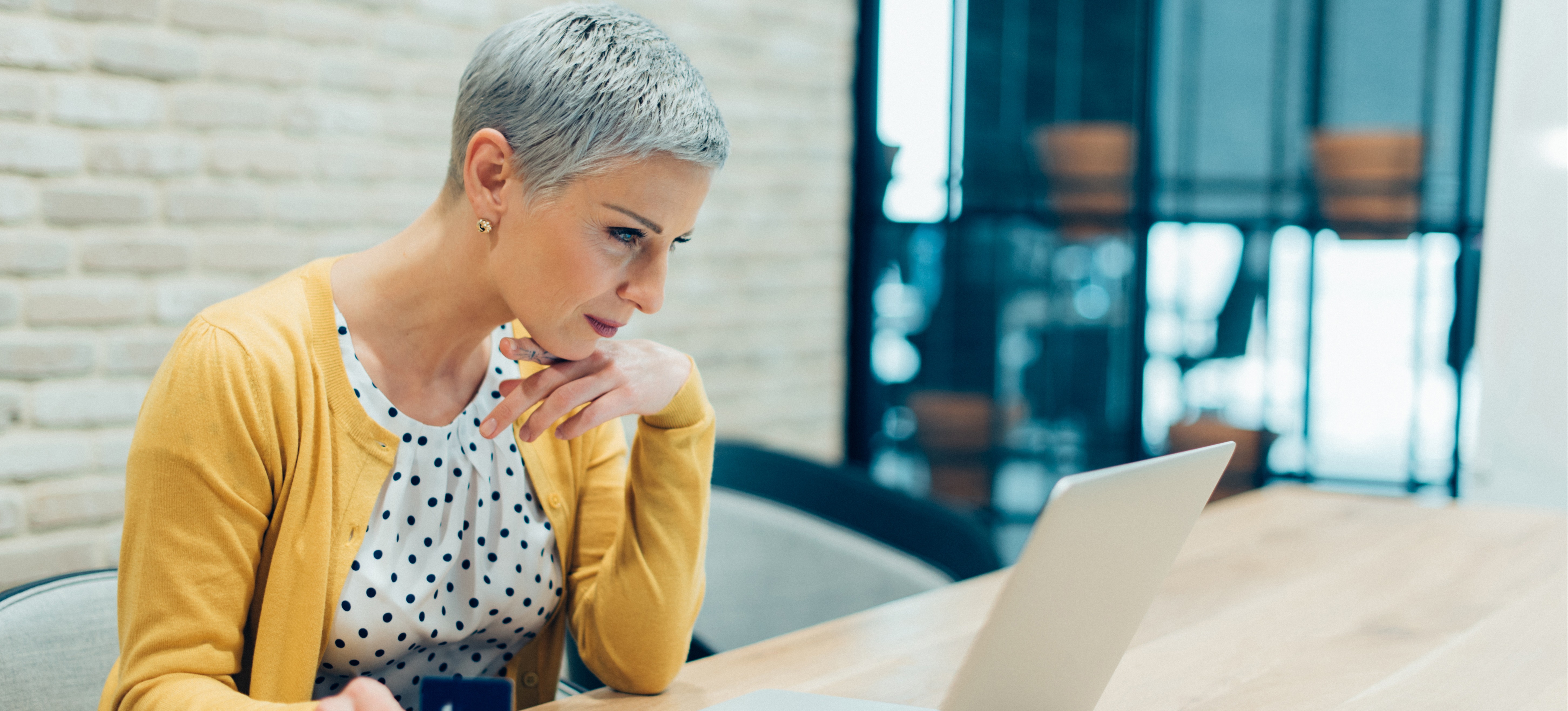 [Featured Image] A woman who is shopping online interacts with a chatbot on her laptop, an example of natural language processing. 