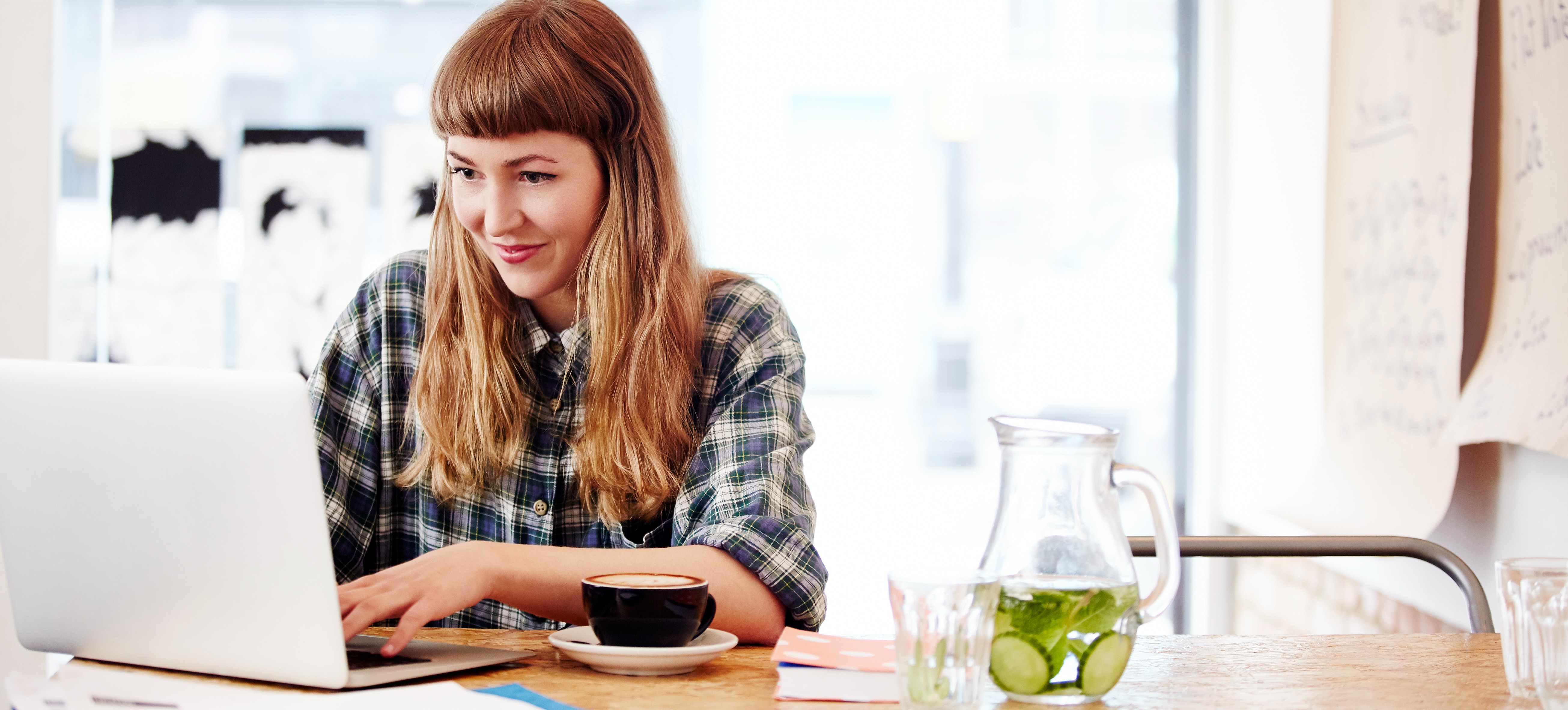 [Featured Image] A computer science learner researches AI versus deep learning on a laptop in a brightly lit coffee shop while planning their career path. 