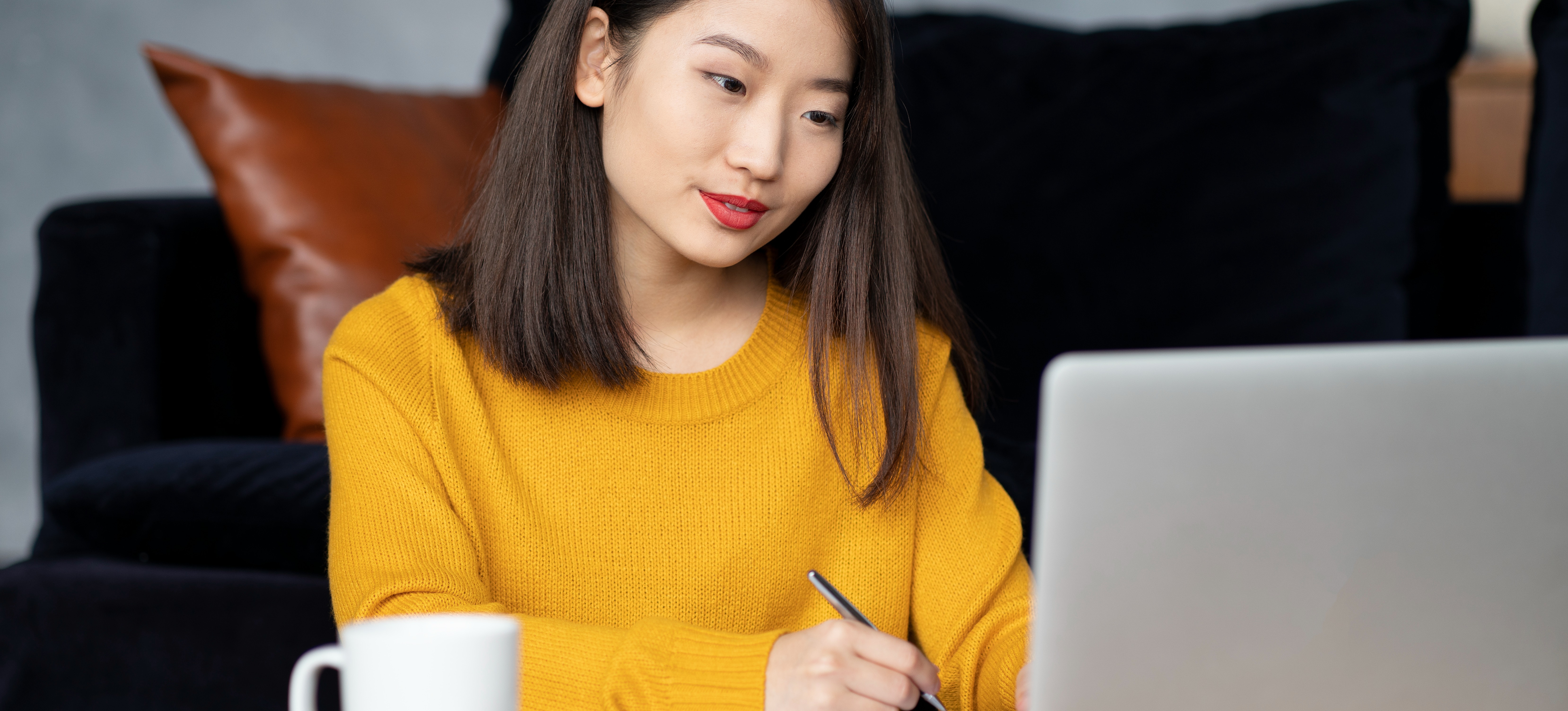 [Featured Image] An accounting clerk sits at a desk with a laptop and writing materials, helping to process their company’s financial data.
