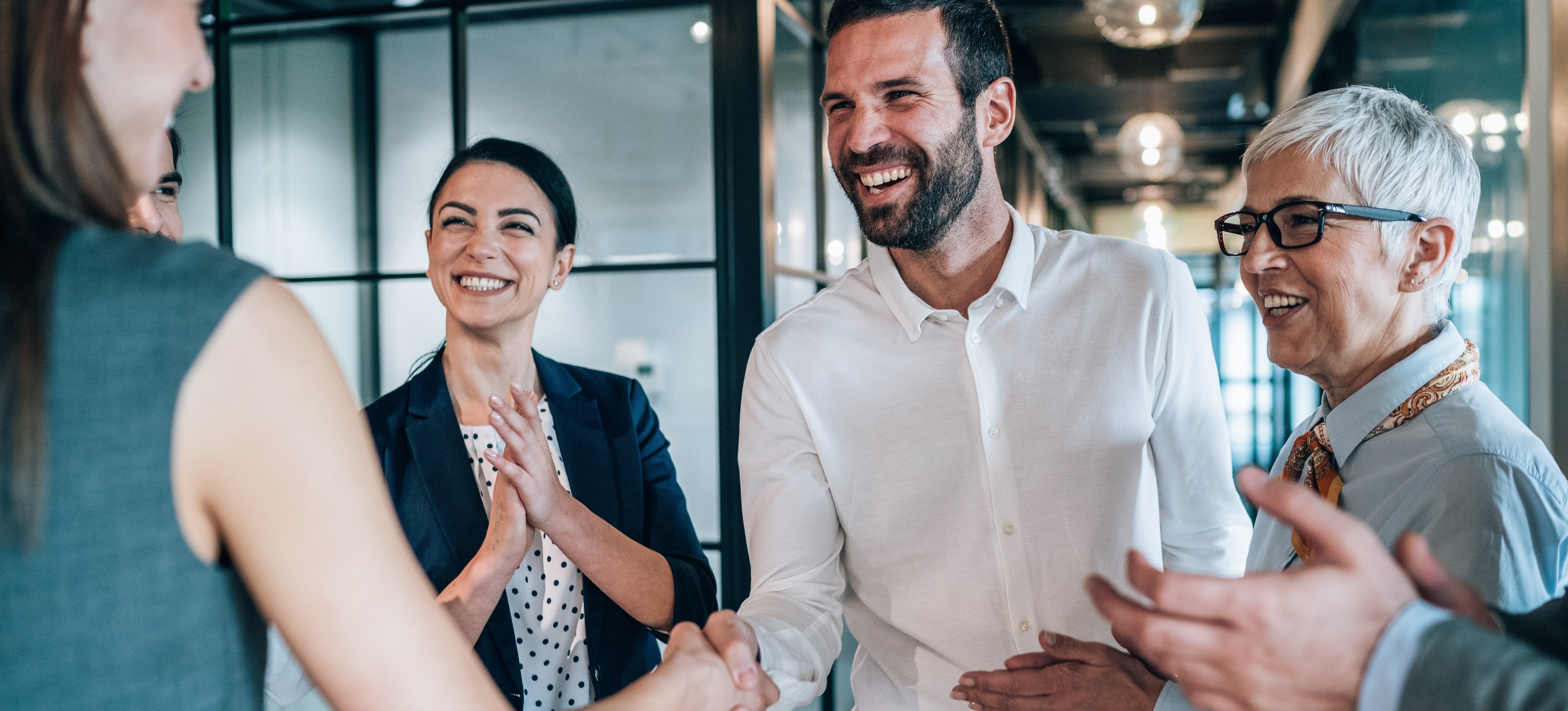 [Featured image] A sales team closes a deal on a new customer acquisition with a handshake.