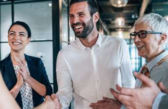 [Featured image] A sales team closes a deal on a new customer acquisition with a handshake.