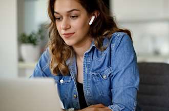 [Featured Image] A woman sitting at a desk earns an Azure certification online. 