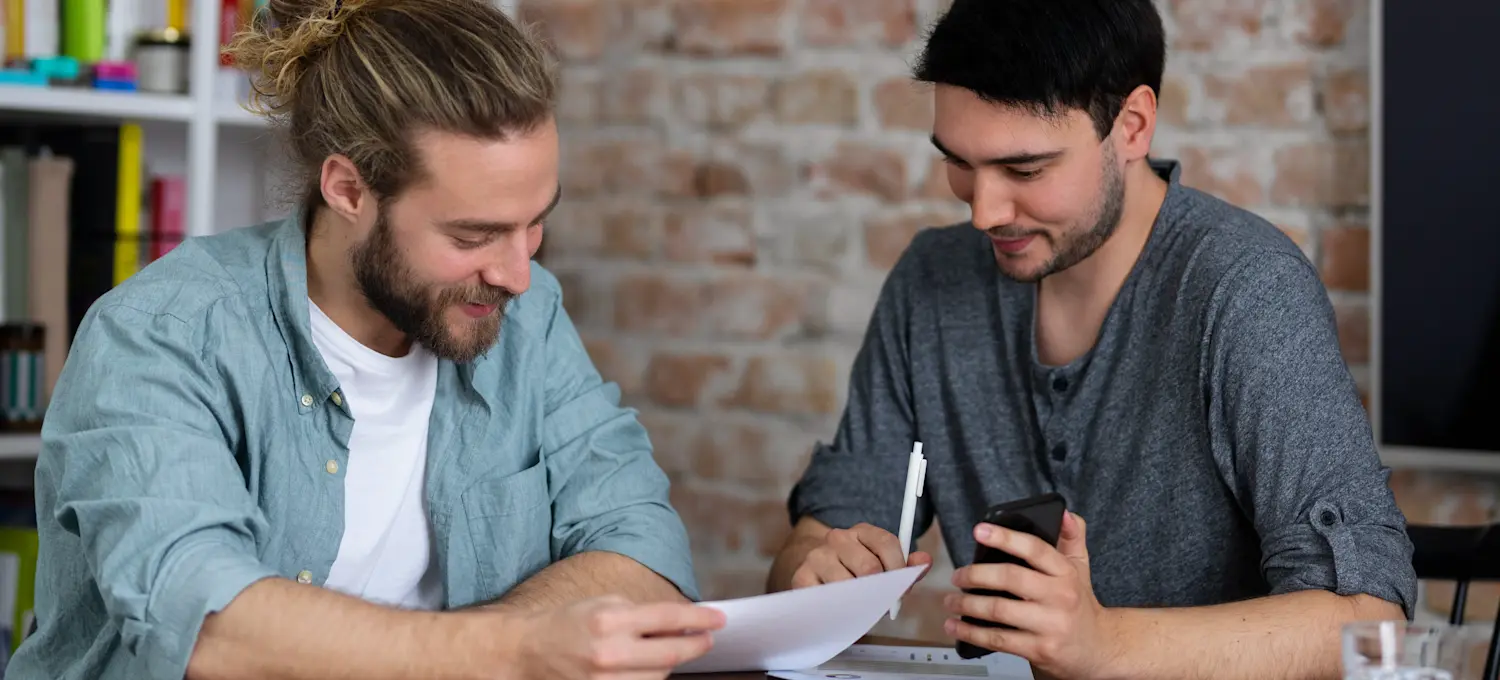 [Featured Image] Two college students look over student records to determine if a high GRE can compensate for their low GPA