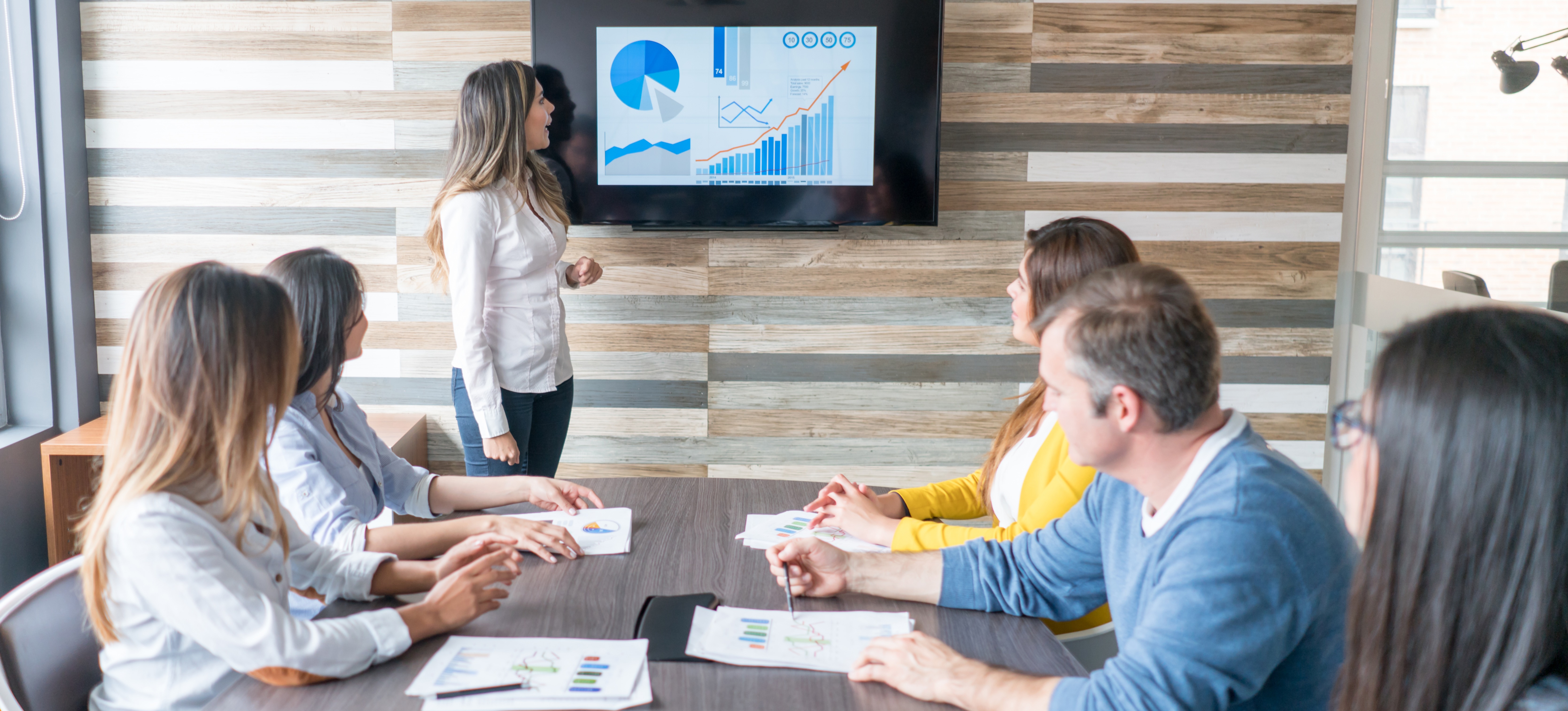 [Featured Image] A business manager presents her gap analysis to senior company stakeholders. 
