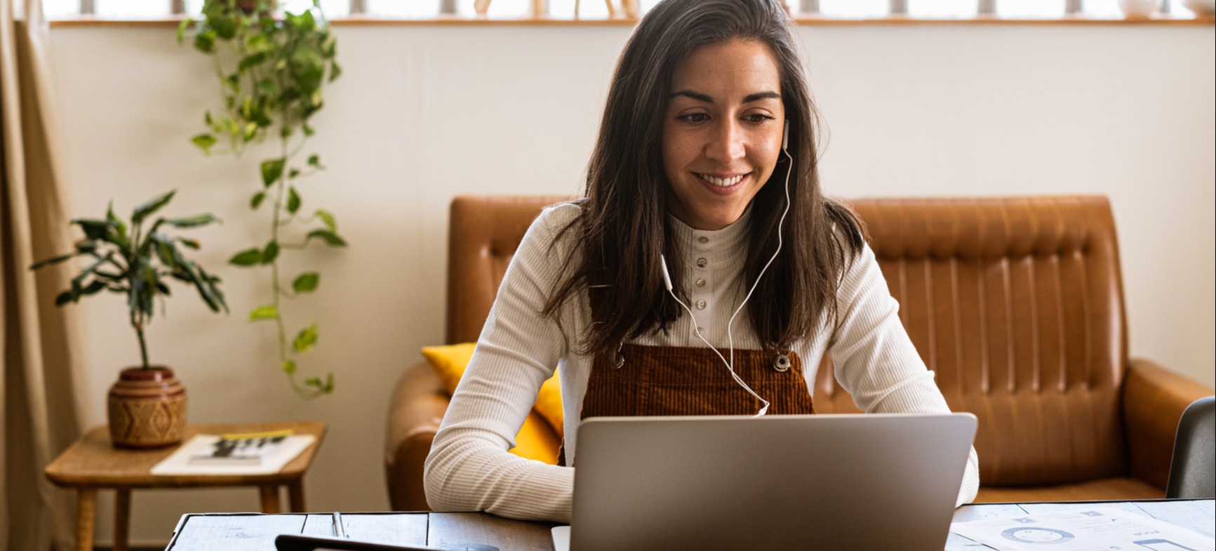 [Featured image] A young professional in a white shirt and overalls works on her functional CV on a laptop computer.