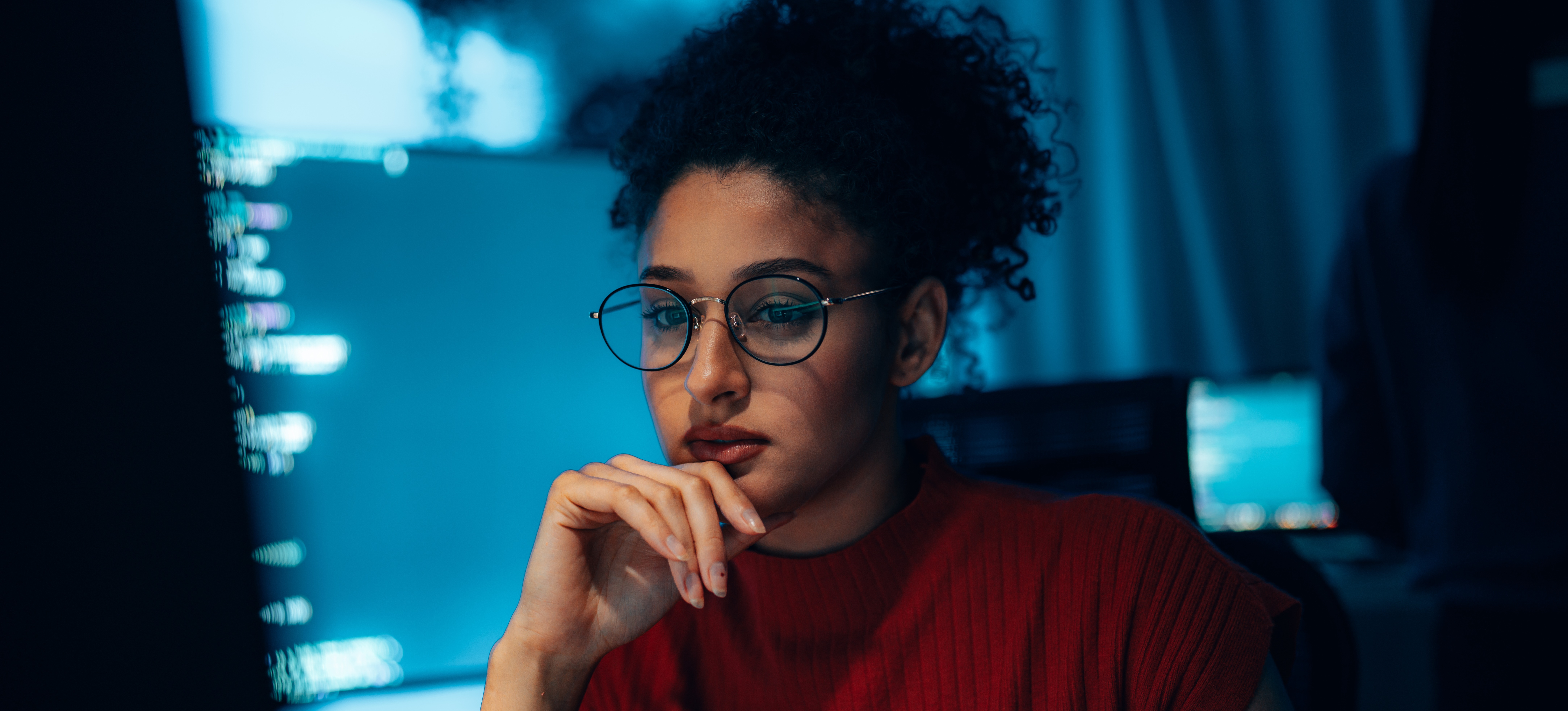 [Featured Image] A security engineer studies their latest project, a security system they are working on refining.

