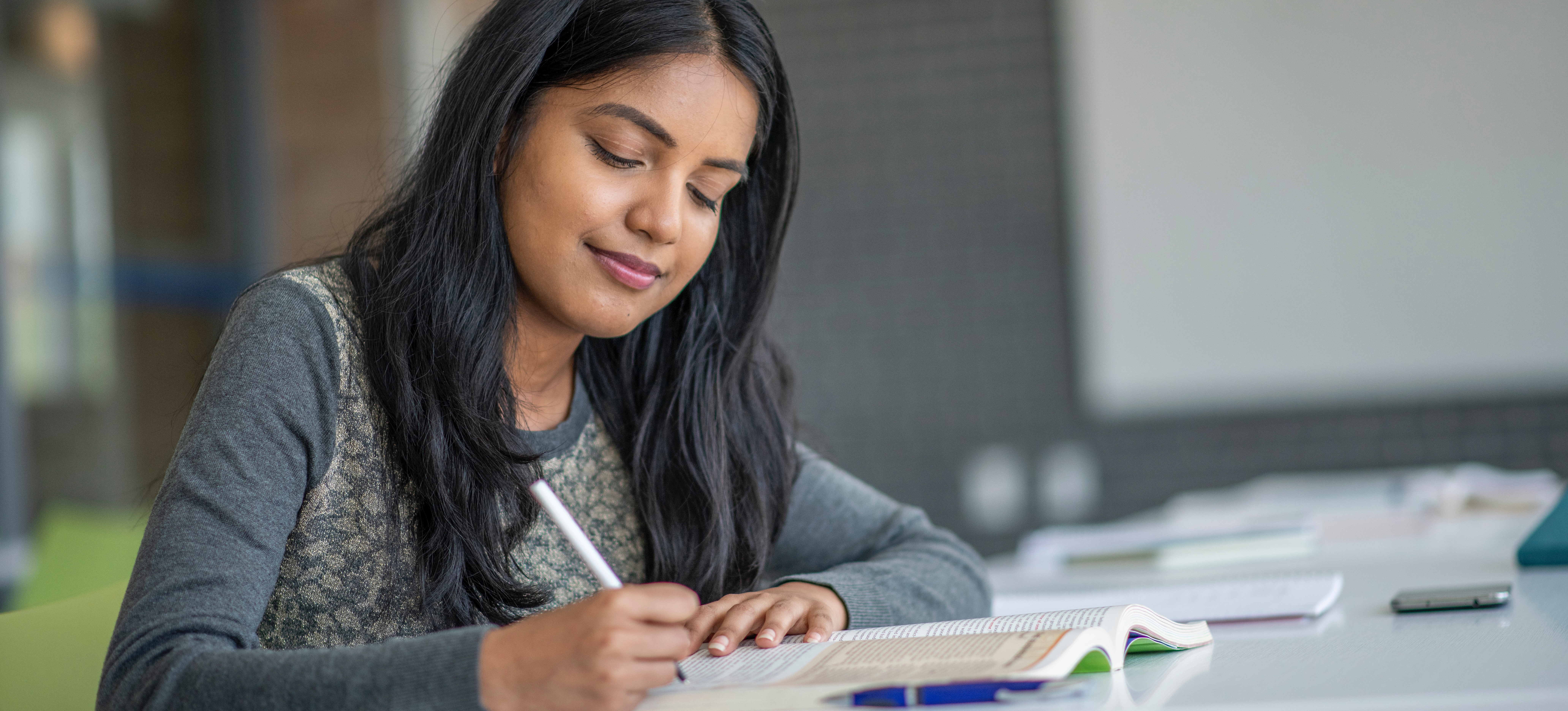 [Featured Image]: A person sits at a desk and studies environmental policies in India. 
