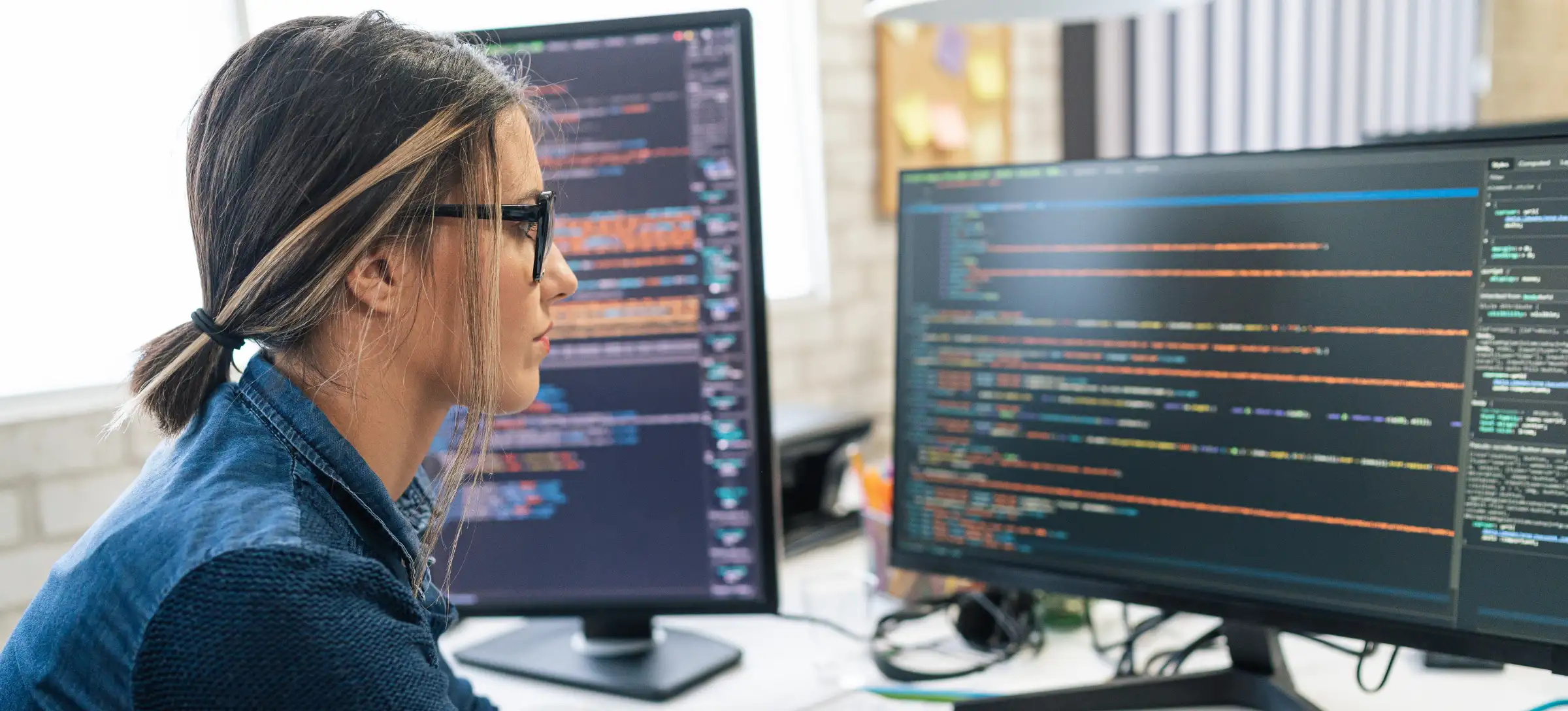 [Featured Image] A person working at a computer with two monitors improving the data governance framework for their company.