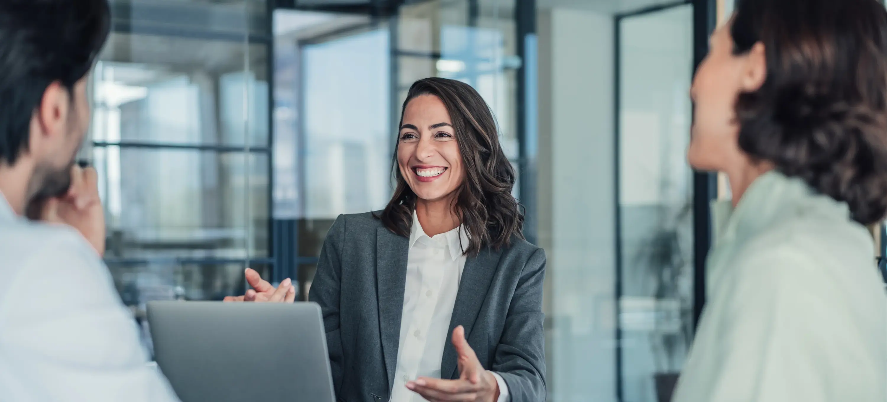 [Featured Image] After achieving QuickBooks certification, an accountant is more qualified to help their team as they talk in a business meeting.