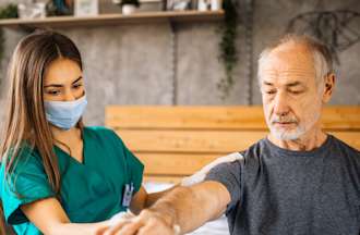 [Featured Image]: Home Health aide providing palliative care to a patient.