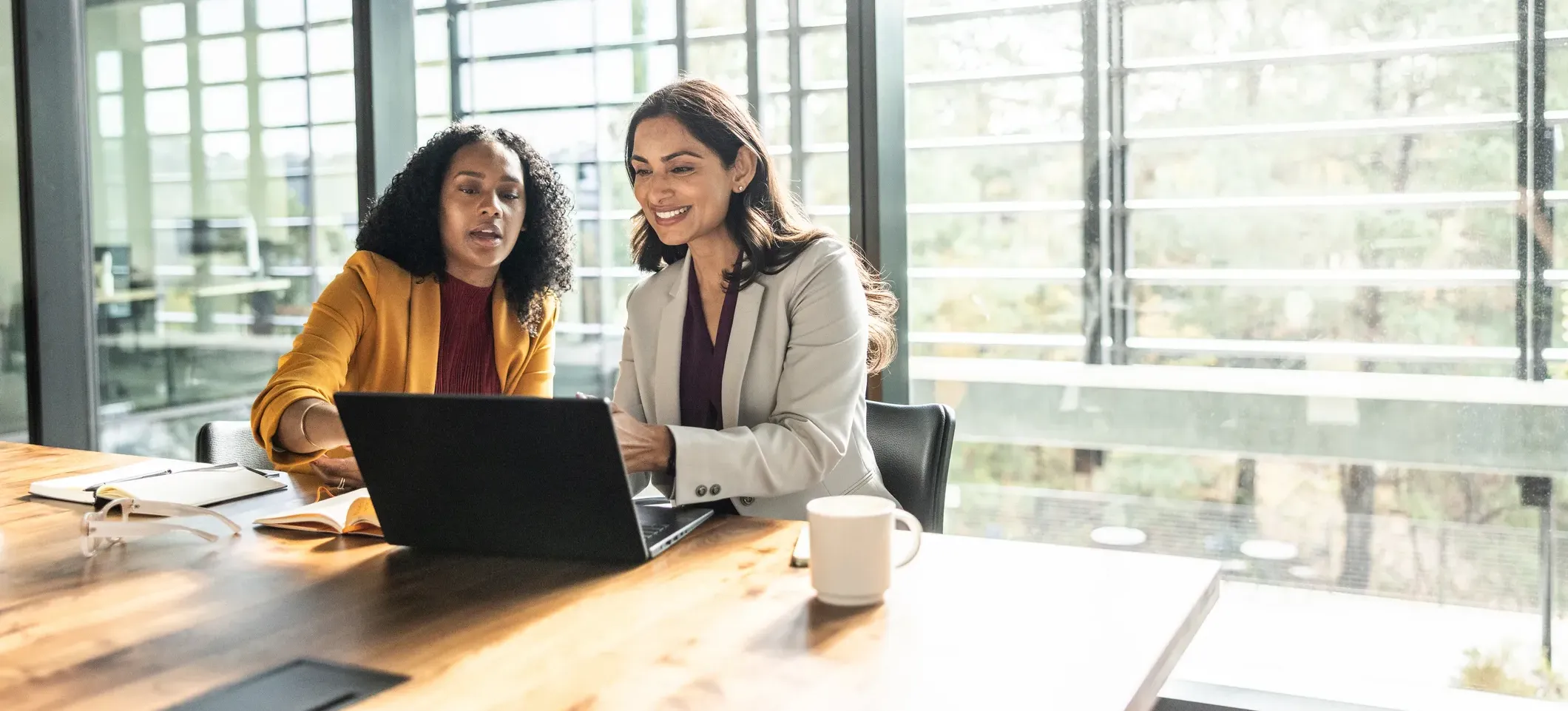 [Featured Image] Two AI developers sit in a sunny conference room exploring MCP and its potential to meet their company’s automation needs.
