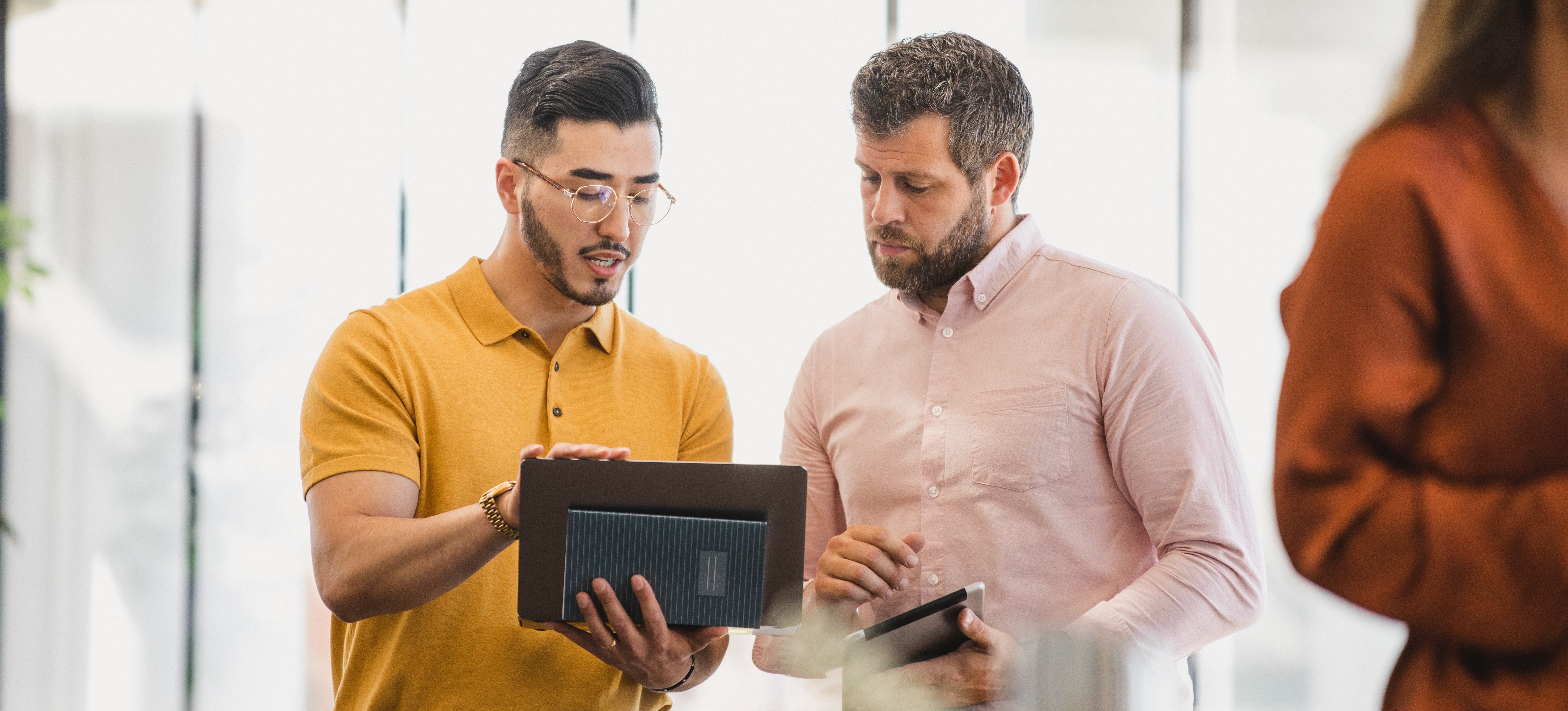 [Featured Image] A man who receives a technical consultant salary shows his client IT business analytics. 