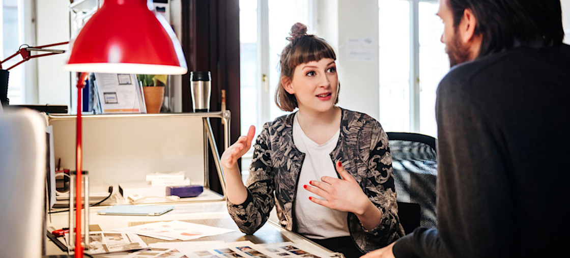 [Featured Image] Two graphic designers collaborating on a project, using in-demand graphic design skills. 
