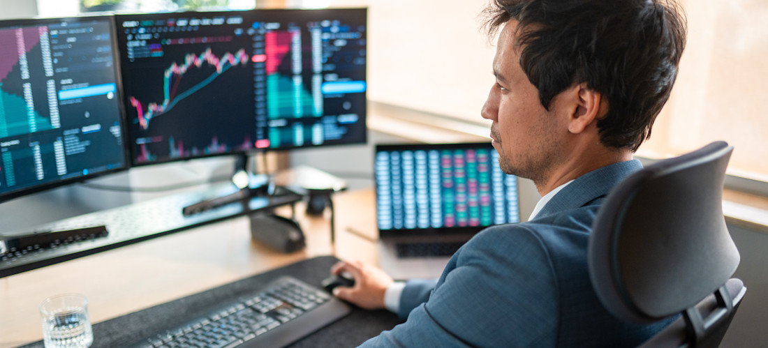 [Featured Image] A blockchain specialist in a professional workspace, analyzing graphs on his computer while working with blockchain development tools.
