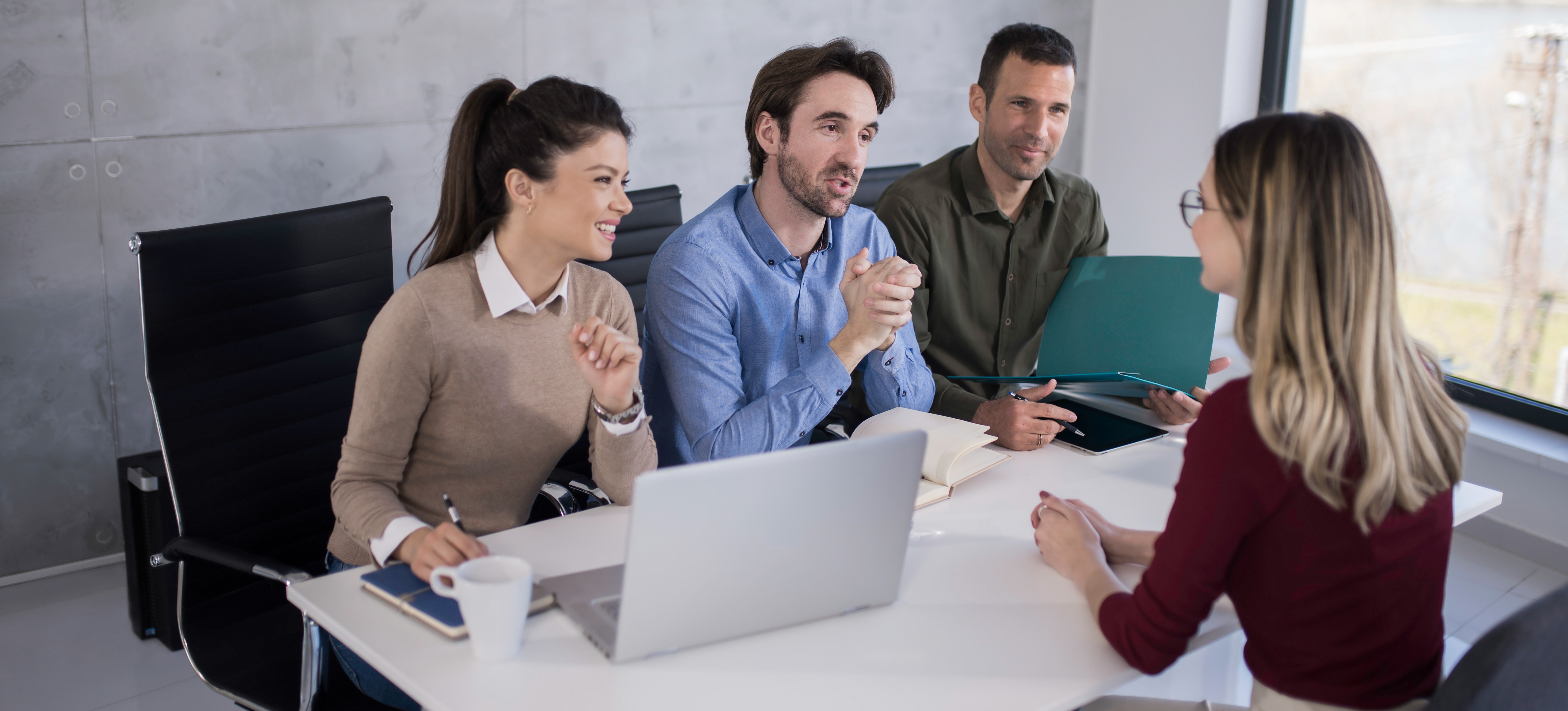 [Featured Image] A group of professionals asks prompt engineering interview questions as they evaluate a potential new hire. 
