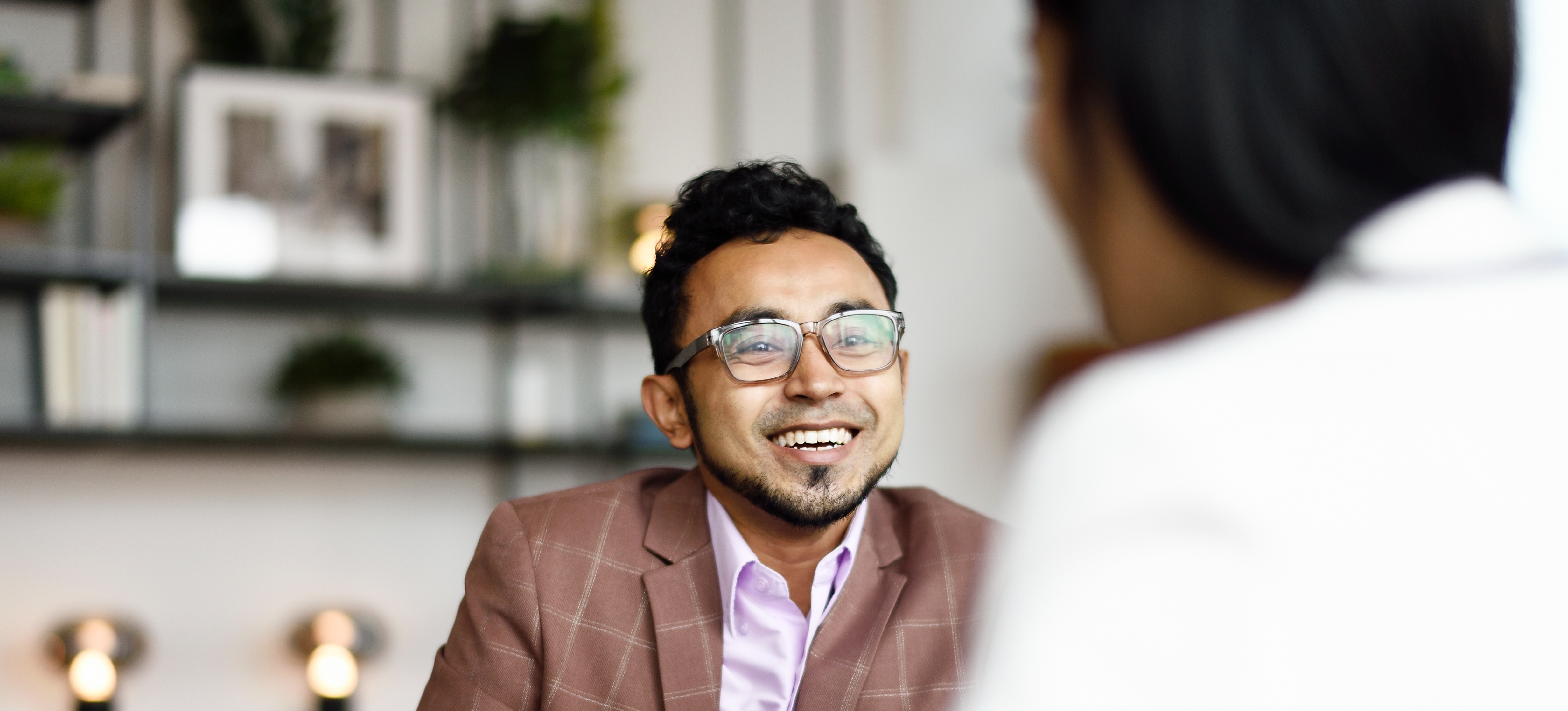 [Featured Image]:  An accountant, discussing with their co-worker going over the financial books of their small business. 