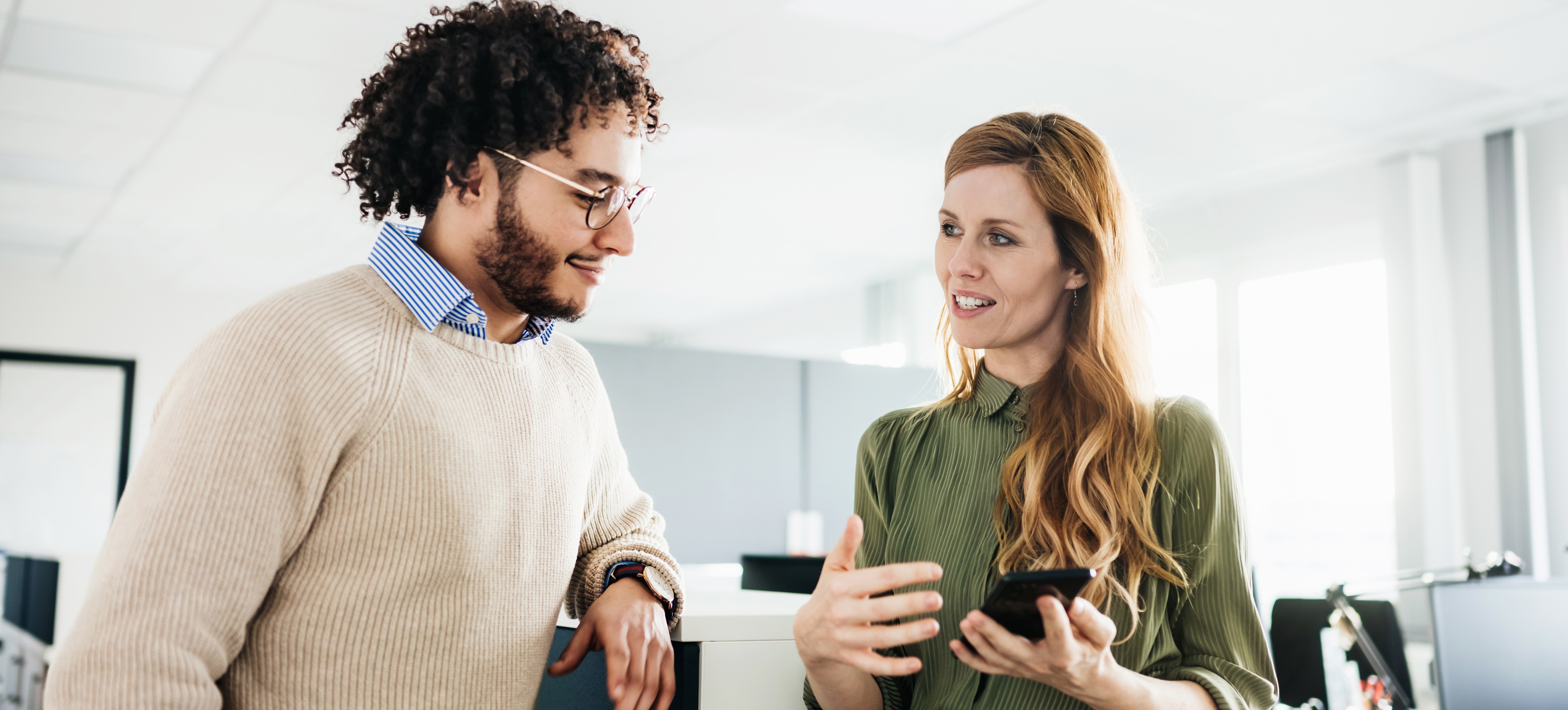 [Featured Image] Two colleagues discuss an issue and use decision making skills to come up with a solution.