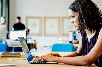 [Featured Image] An employee works on a laptop and uses cross validation in machine learning to evaluate a data model's performance. 