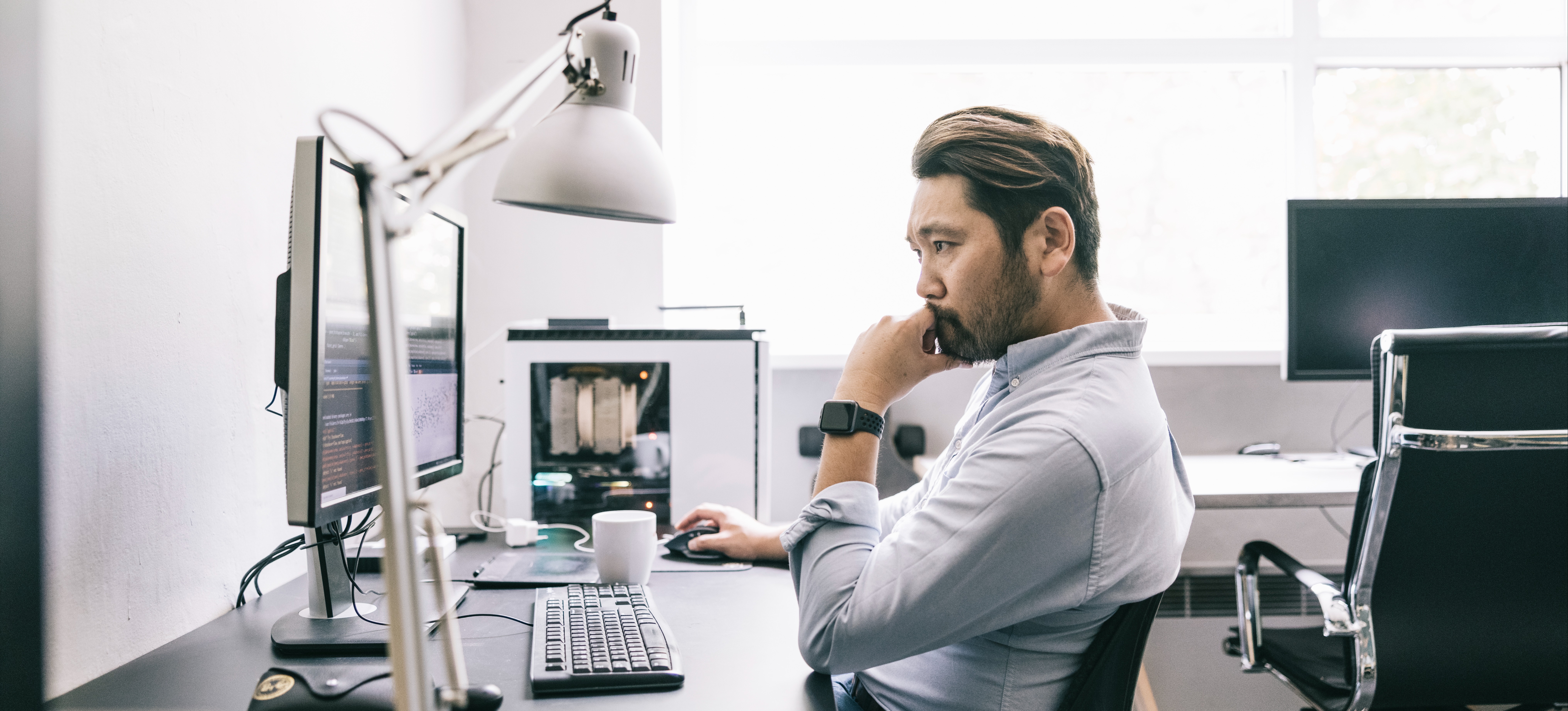 [Featured Image] A neural network engineer analyzing data on a computer screen in a brightly lit office settting.
