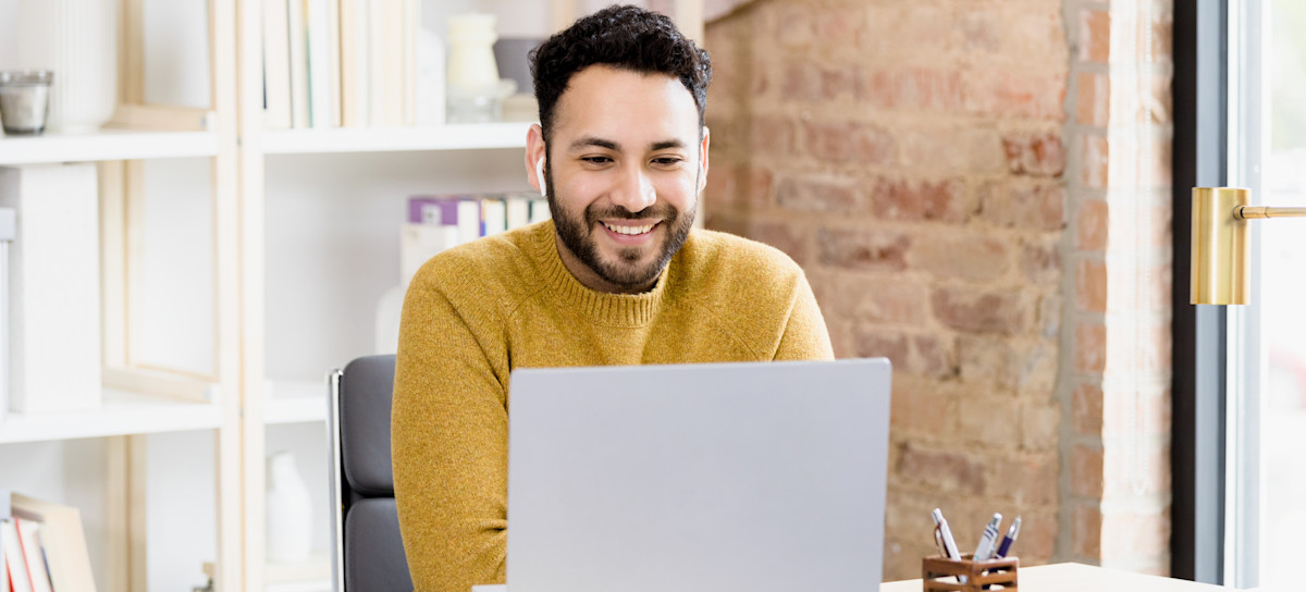 [Featured Image] A worker contemplating a job change uses their laptop at home to read a DevOps job description. 
