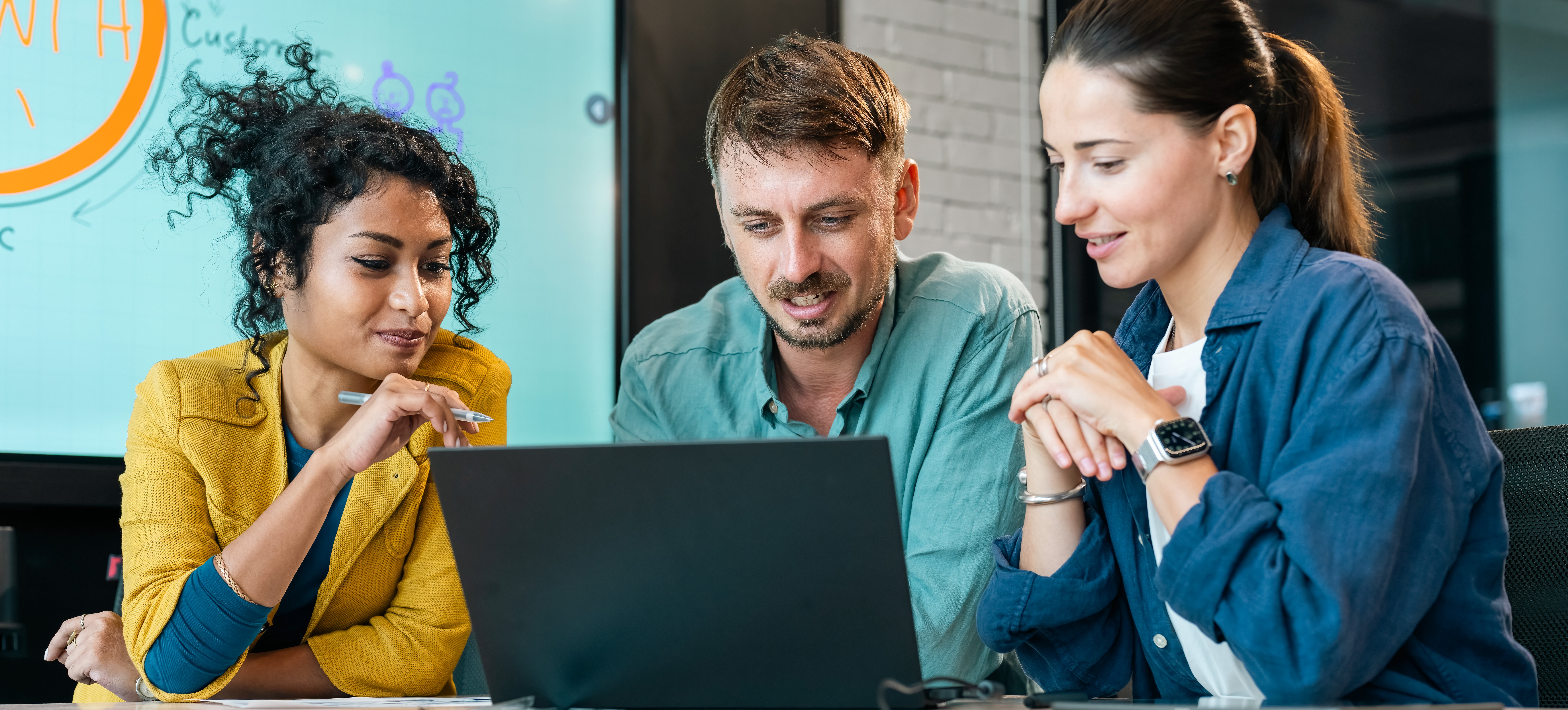 [Featured Image] Colleagues collaborate at one of the best real estate companies to work for as they engage in a professional workspace.