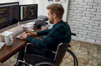 [Featured Image] SQL Developer in front of several monitors.