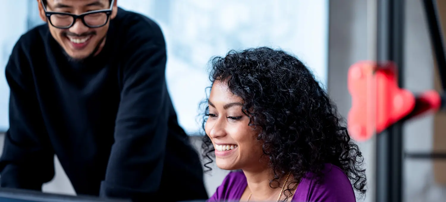[Featured Image] Cloud data engineers collaborating in a professional environment, smiling while working together on cloud-based data solutions.