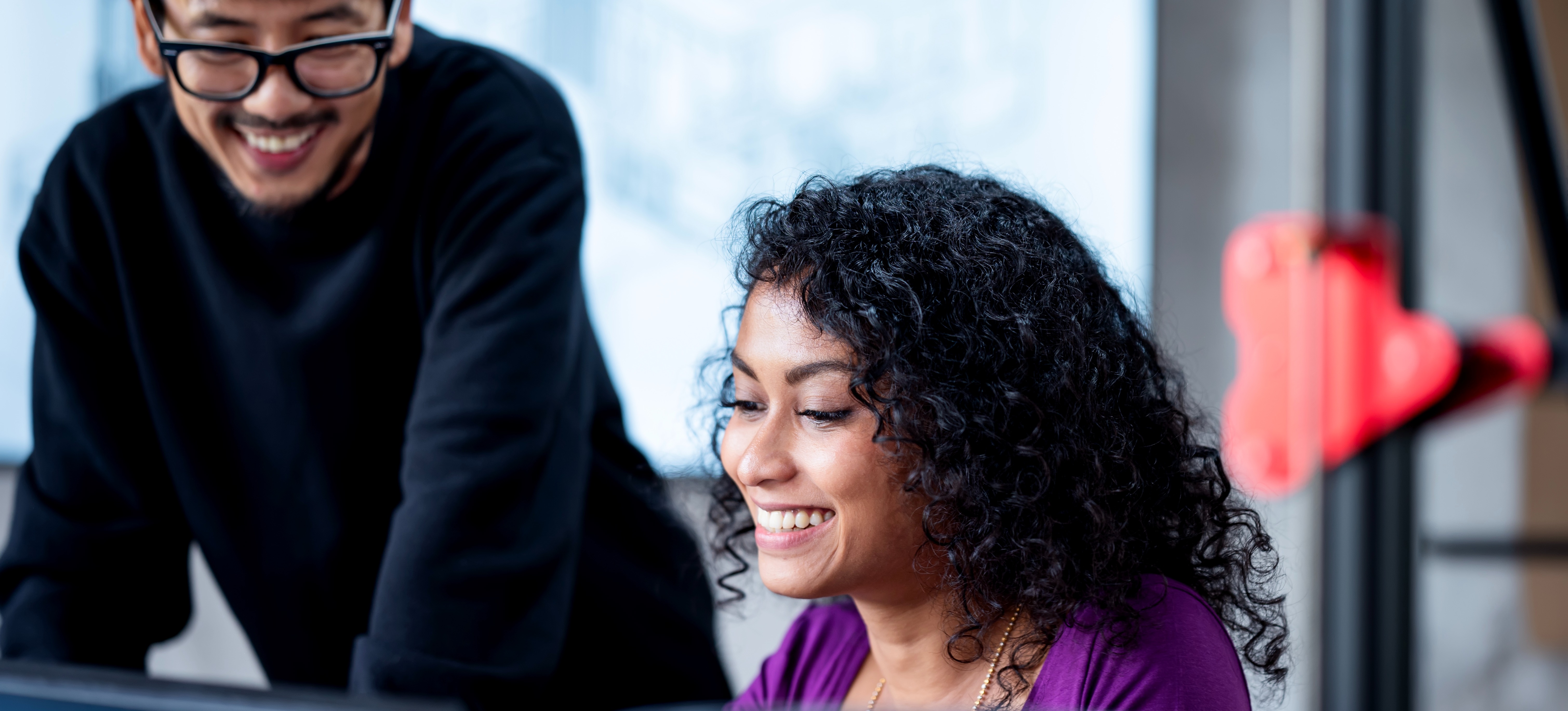[Featured Image] Cloud data engineers collaborating in a professional environment, smiling while working together on cloud-based data solutions.