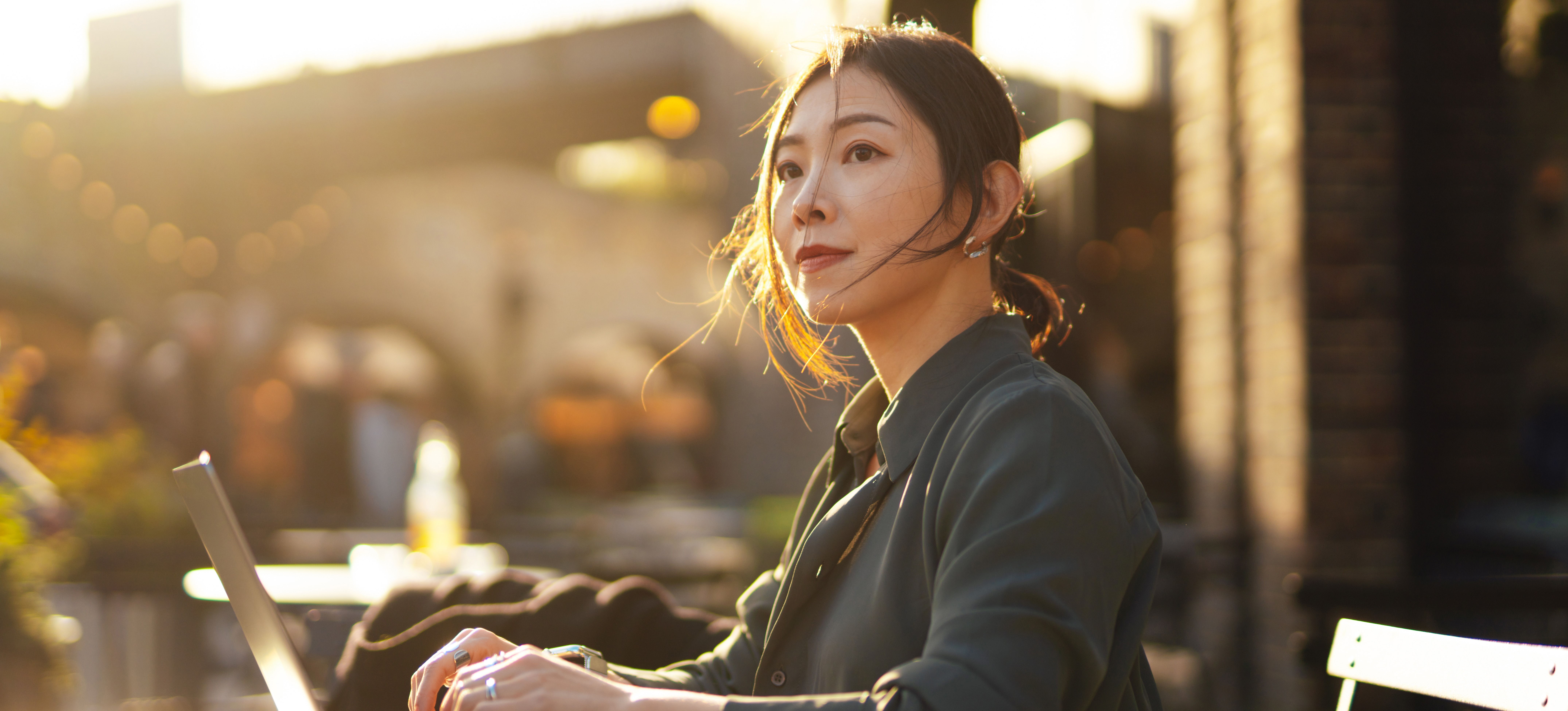 [Featured Image] An AI professional sits outdoors, working on a laptop.
