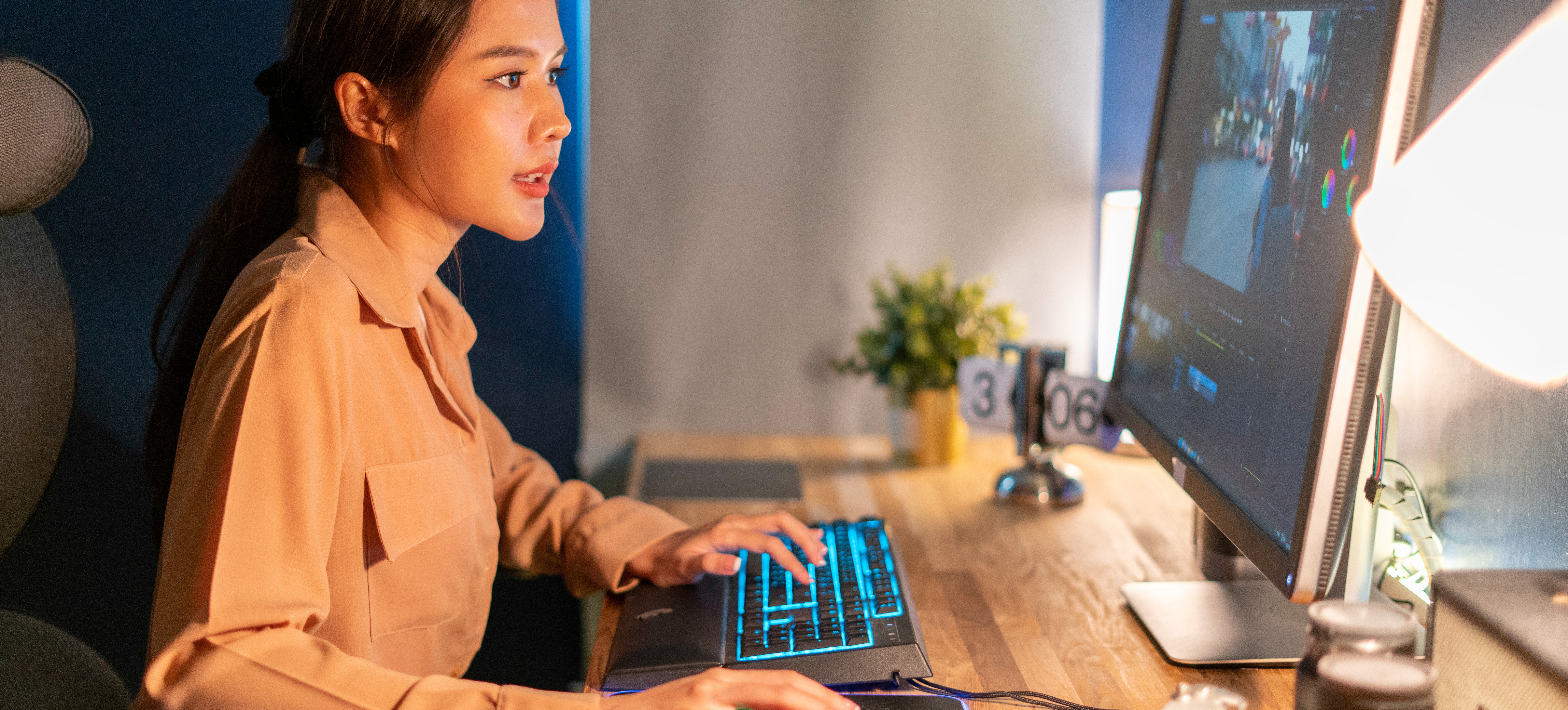 [Featured Image] A video editor working on a computer with a video editing platform open, making adjustments to a project.
