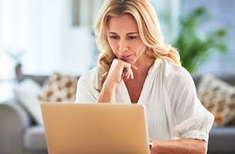 [Featured image] A health care business intelligence analyst works on her laptop from home, analyzing data for actionable insights.
