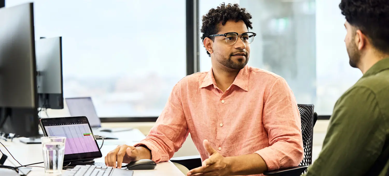 [Featured image] Two businesspeople at a computer decide between OpenStack and Kubernetes to streamline their IT infrastructure.