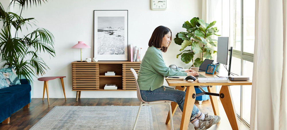 [Feature Image] A dark-haired learner attends an online class on natural language processing techniques while sitting at a light wood desk in their home office. 
