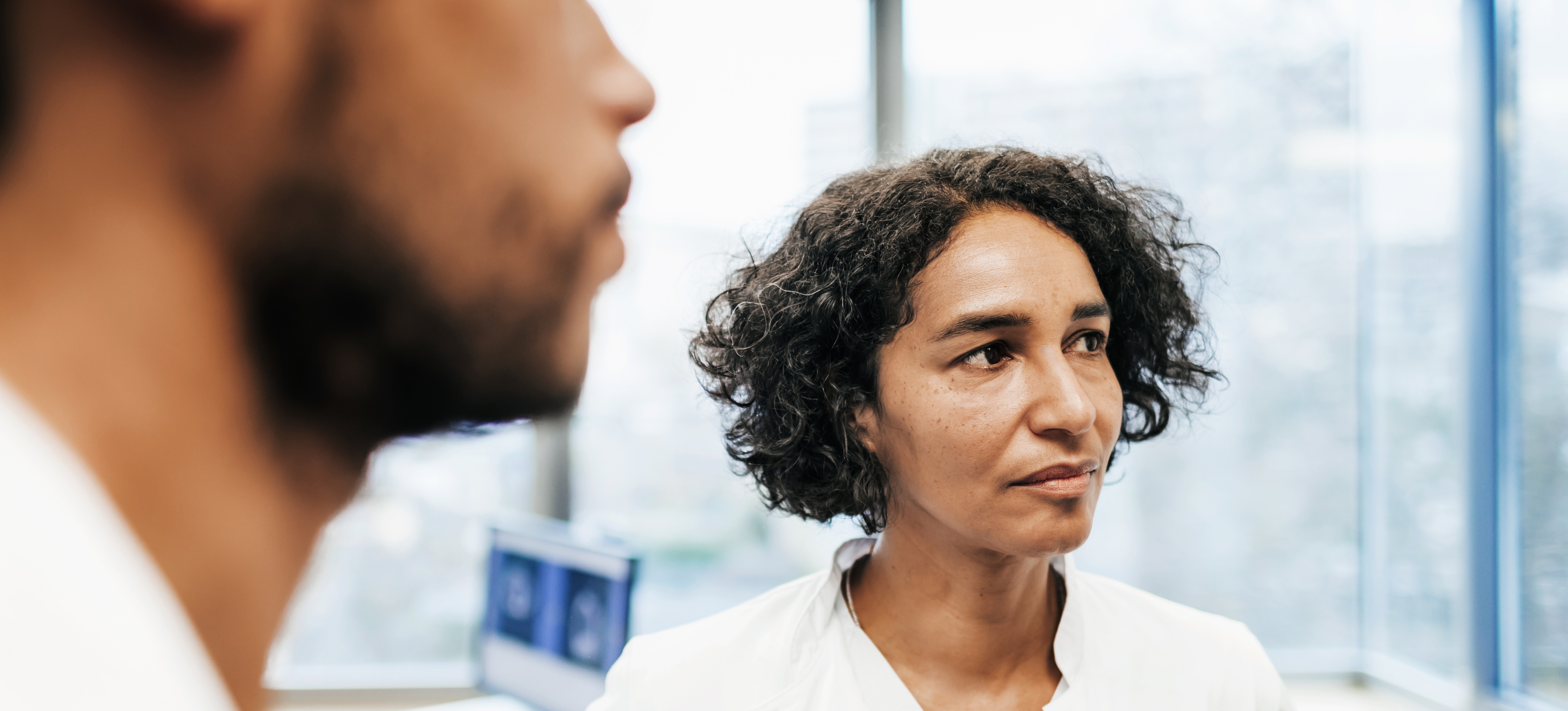 [Featured image] A certified medical assistant in a white lap coat looks at lab results with a physician.