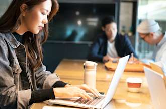 [Featured image] A student in a cybersecurity degree program is working at a coffee shop.