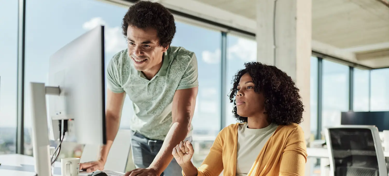 [Featured image]: Two learners in front of a computer discuss which AI framework to use for their next project.
