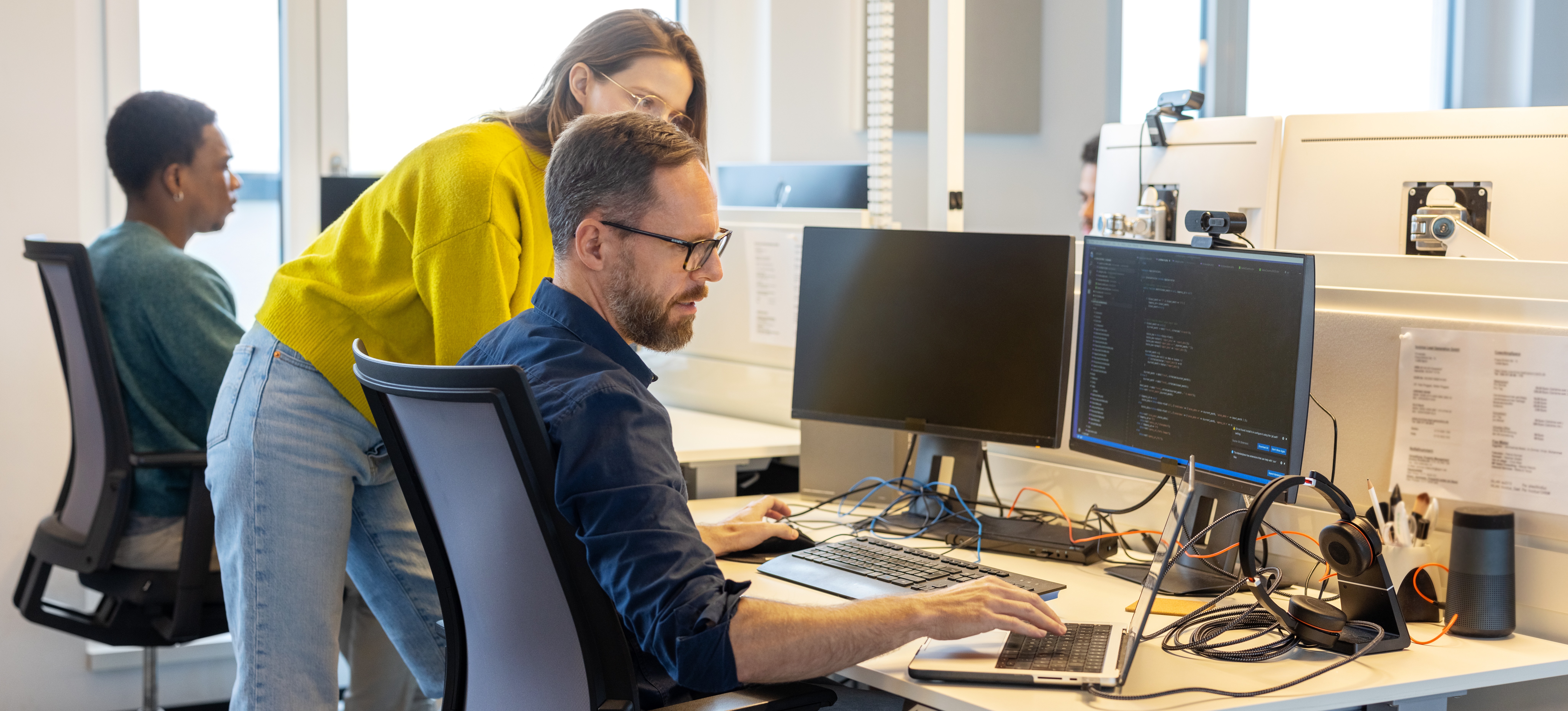 [Featured Image] Developers discussing the implementation of retrieval augmented generation (RAG) in AI applications, analyzing code on their computers in a professional workspace.
