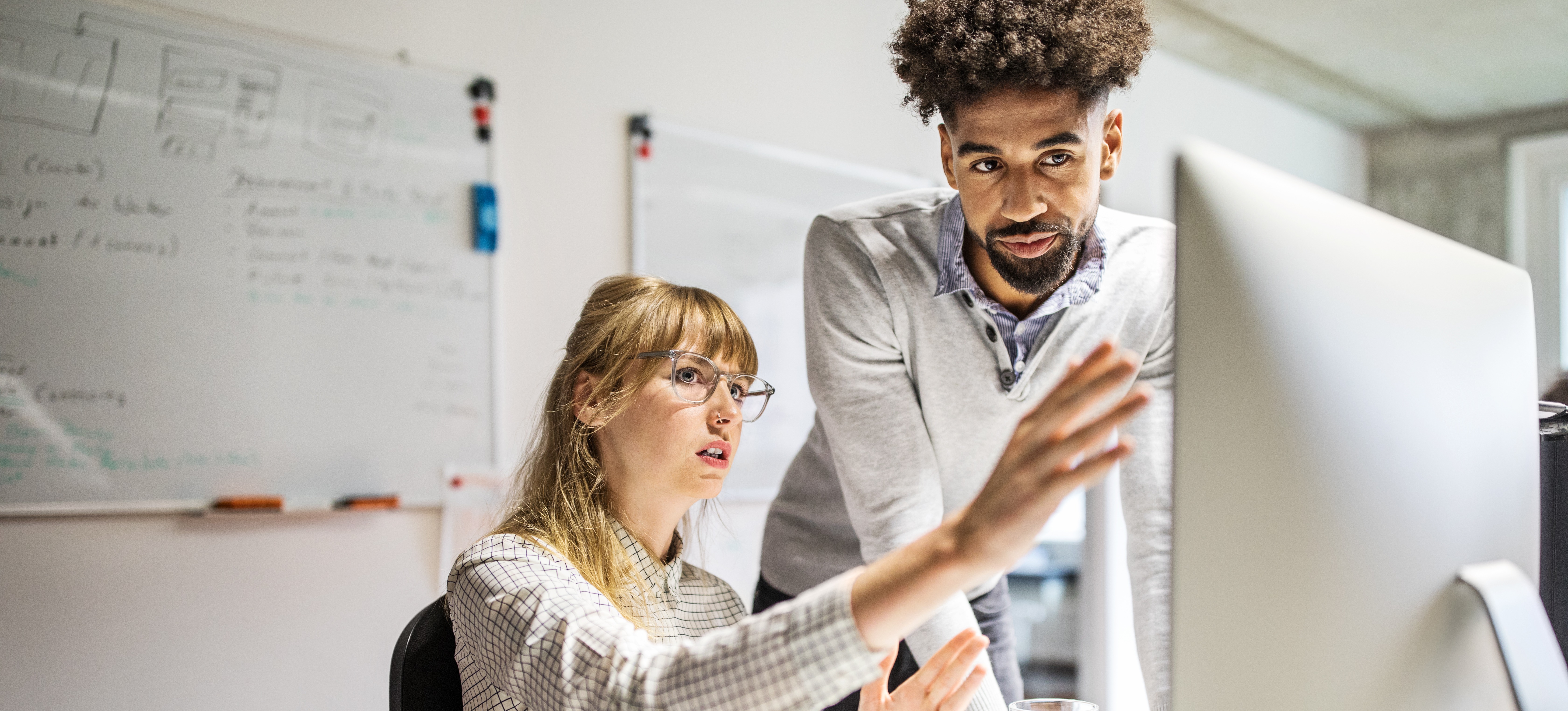 [Image en vedette] Deux employés informatiques discutent de la certification CompTIA Security+.