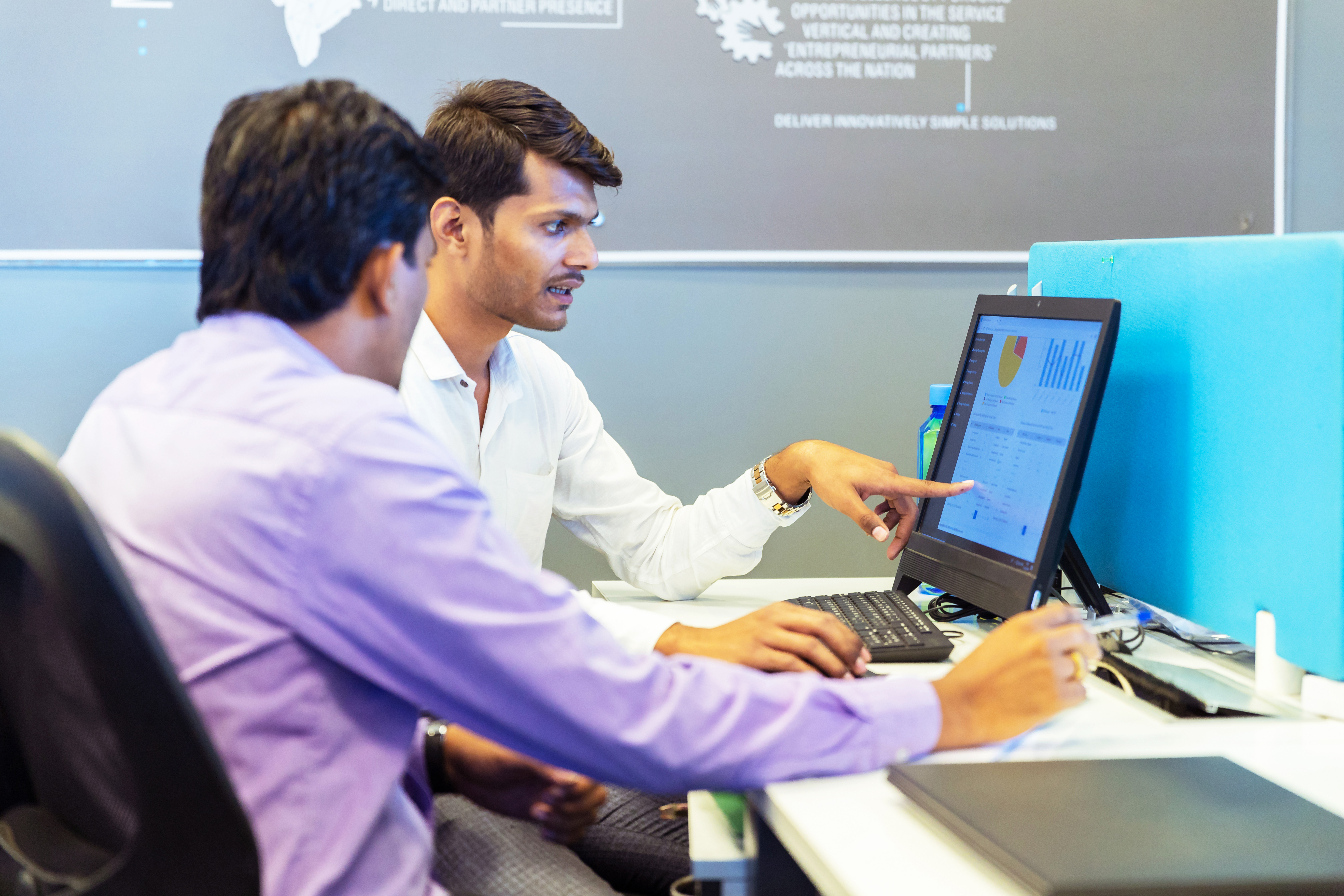 [Featured Image]: Two men use Google Analytics Dashboard to analyze website traffic.
