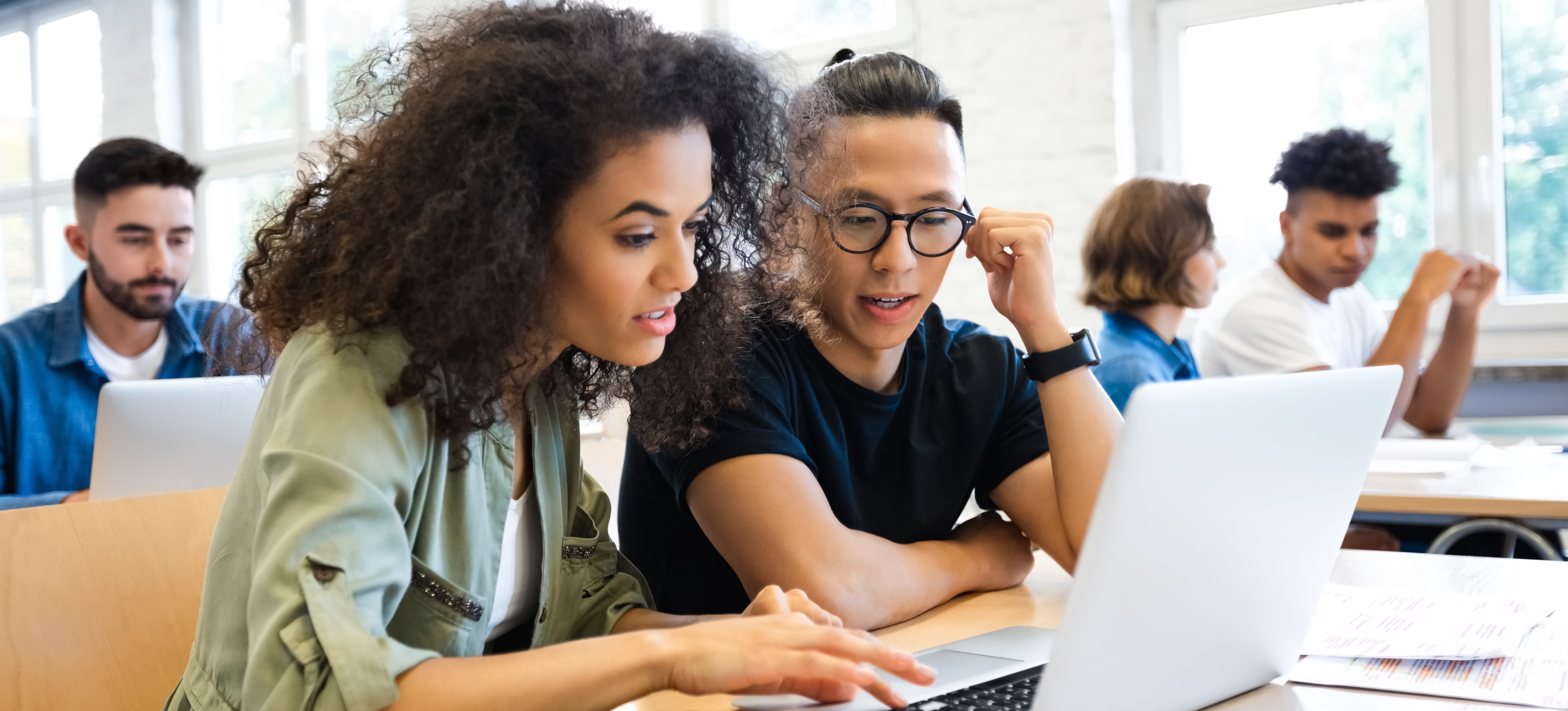 [Featured Image] Two learners work on an assignment at an accredited university. 
