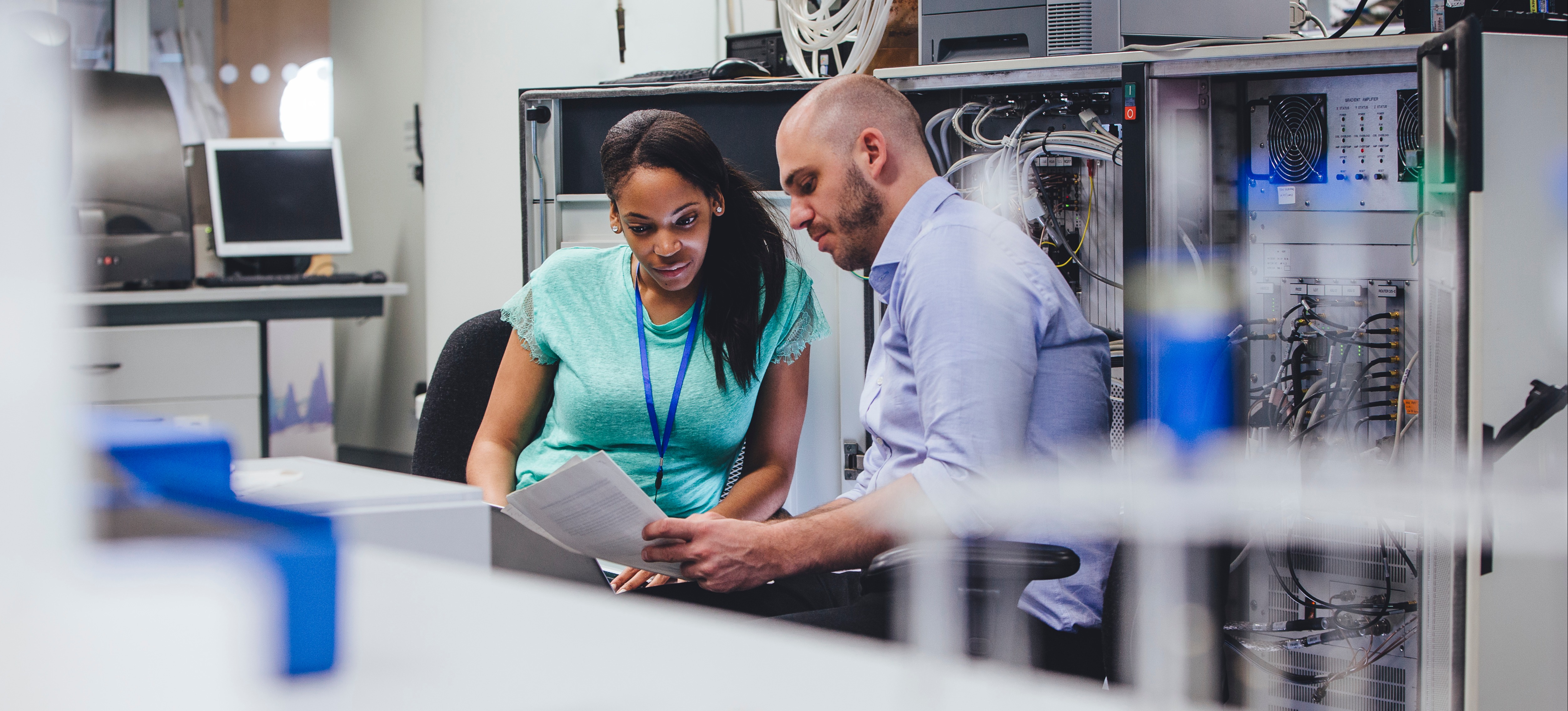 [Featured image] A network administrator consults with a colleague in a server room.