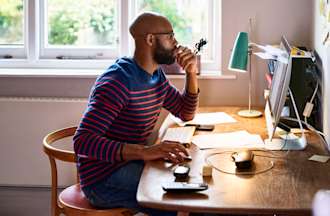 [Featured image] Man at a desk working on taxes on a computer