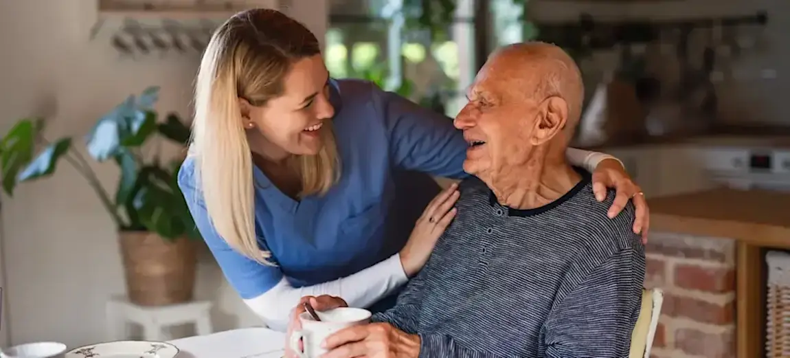 [Featured Image] A social worker works with a senior citizen after learning what degree you need to be a social worker and earning it.   
