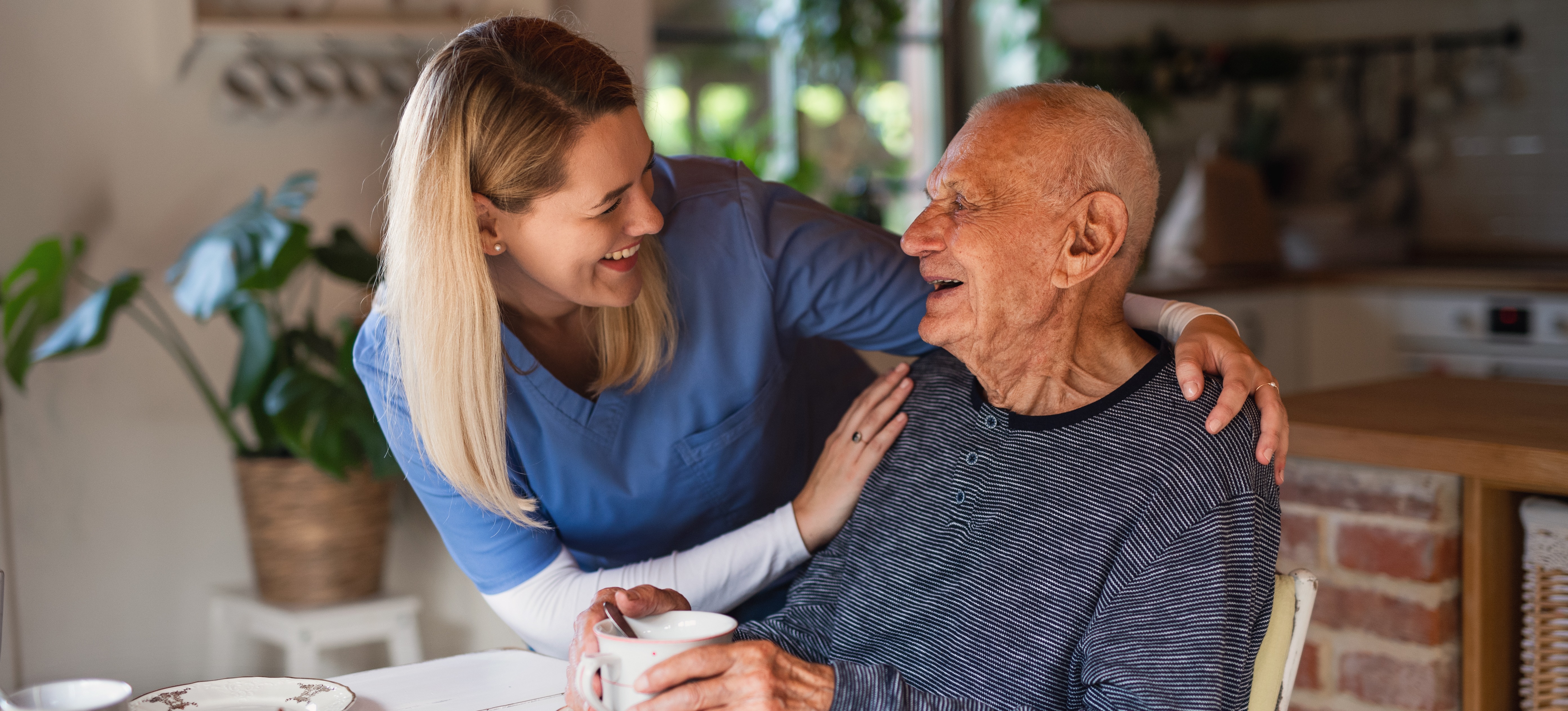 [Featured Image] A social worker works with a senior citizen after learning what degree you need to be a social worker and earning it.   