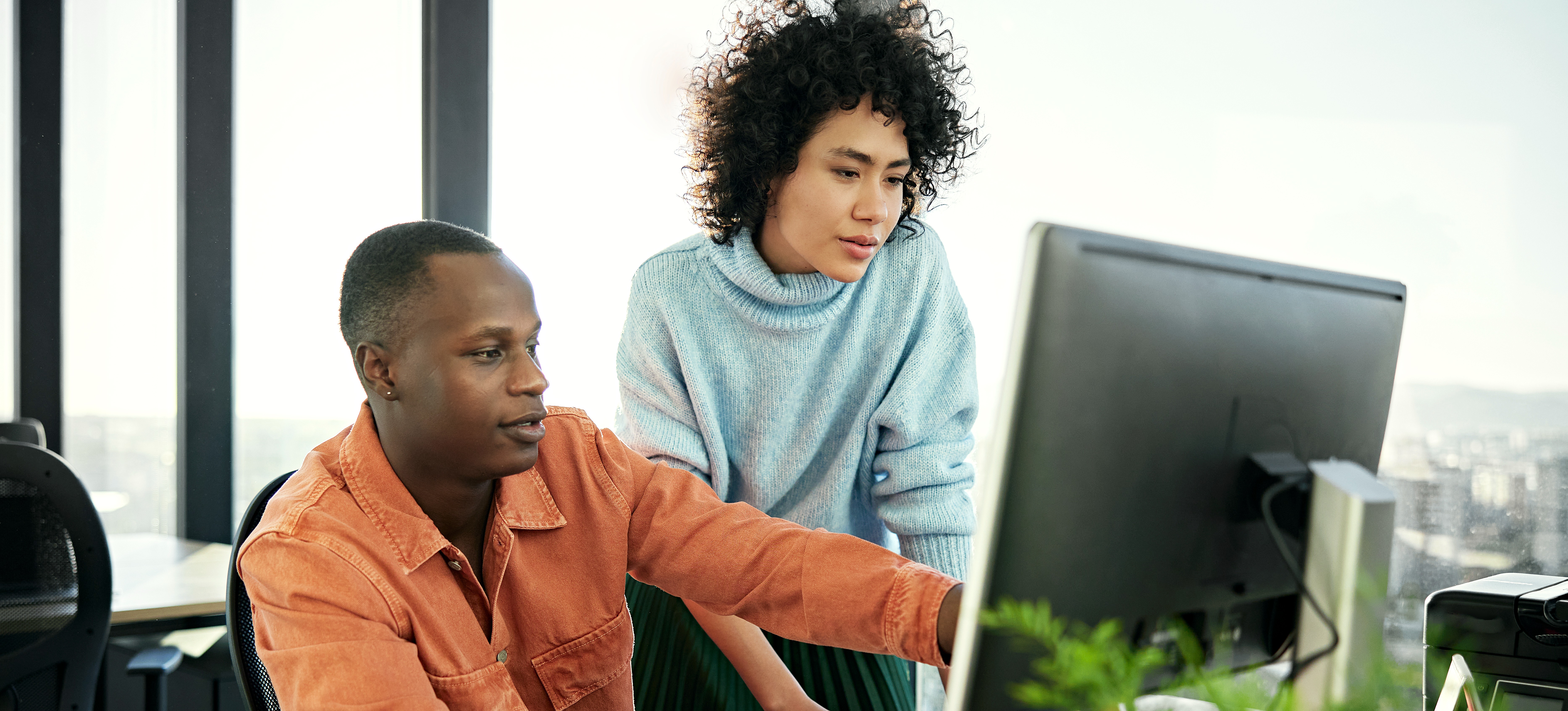 [Image en vedette] Deux développeurs web regardent un écran d'ordinateur pour concevoir une feuille de style en cascade.